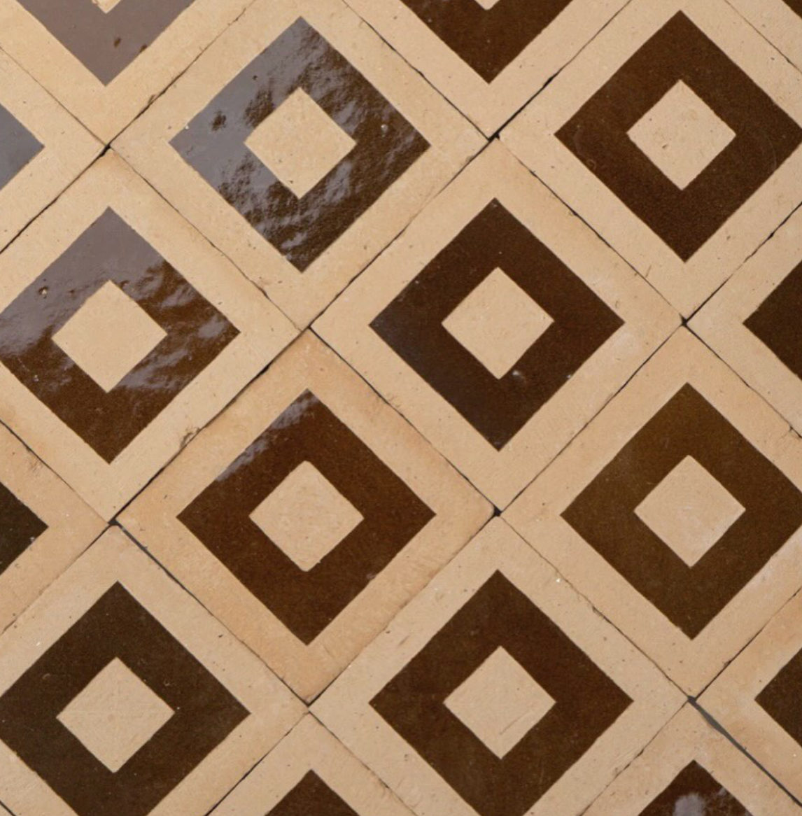 Patterned ceramic tiles on the floor featuring beige and dark brown diamond shapes.