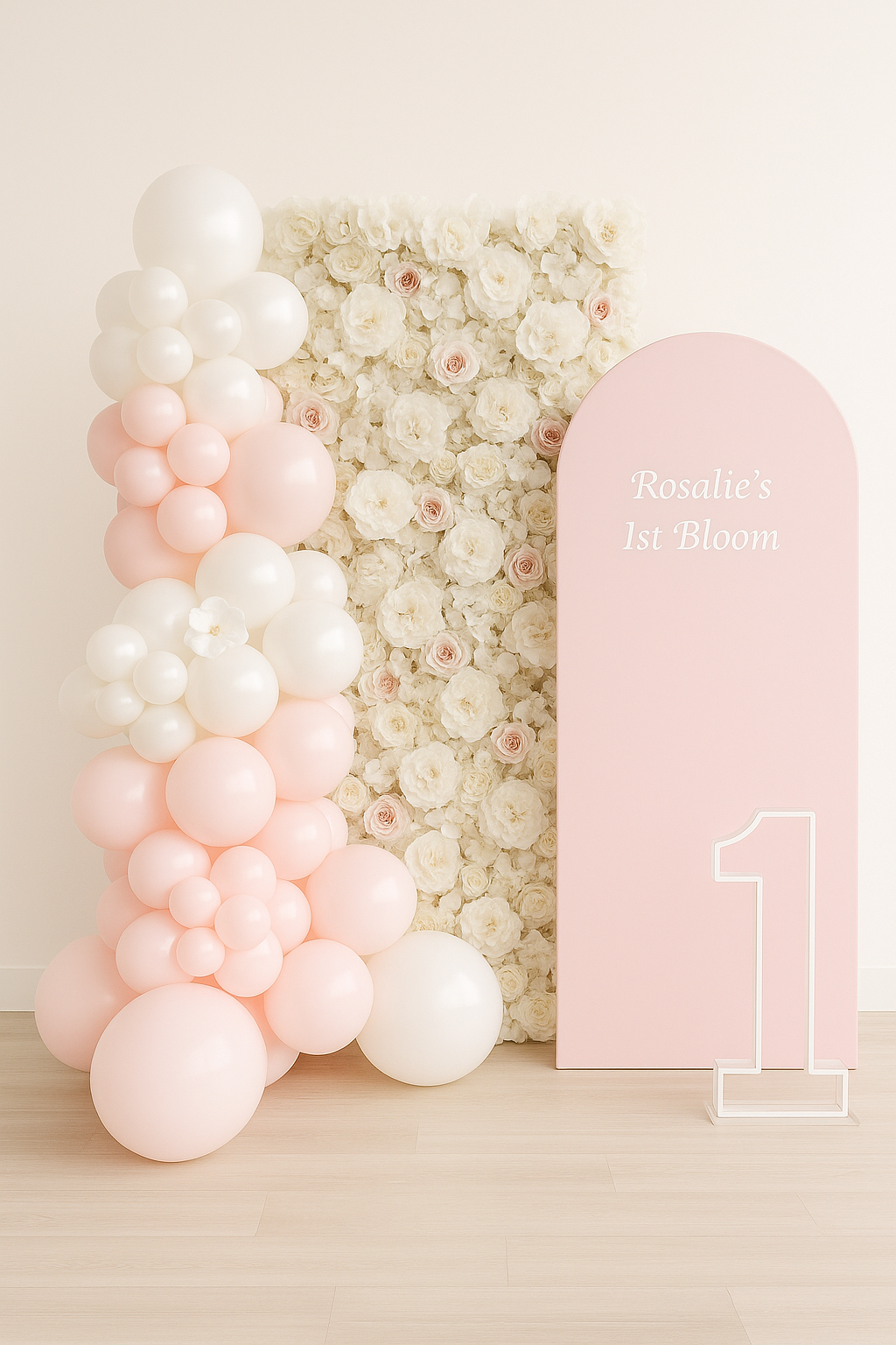 Decorative display with pink and white balloons, a floral backdrop, and a pink sign that reads 'Rosalie's 1st Bloom' with a large number 1
