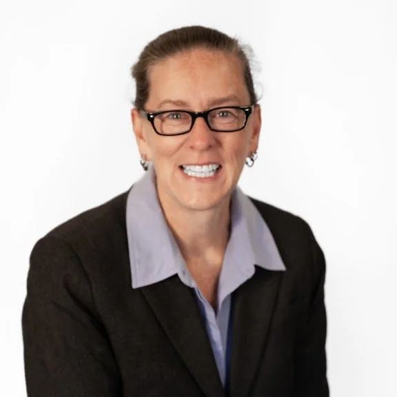 Karen Boutwell, smiling, wearing a business suit and a lavender blouse