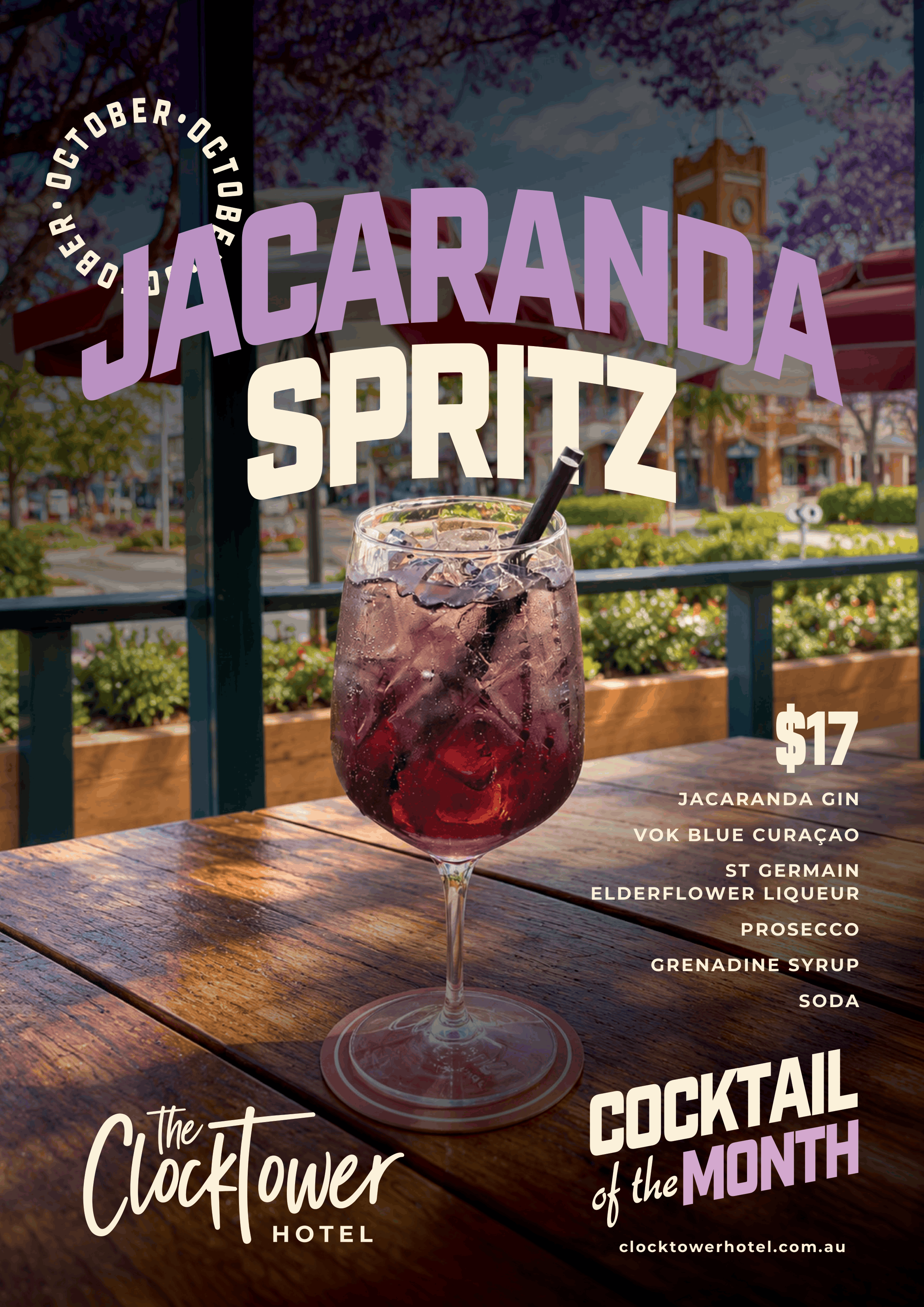 A glass of purple cocktail with ice and a black straw placed on a wooden table outside, with a background of colorful buildings, trees, and a clock tower, advertising the 'Cocktail of the Month' at the Hotel Clocktower.