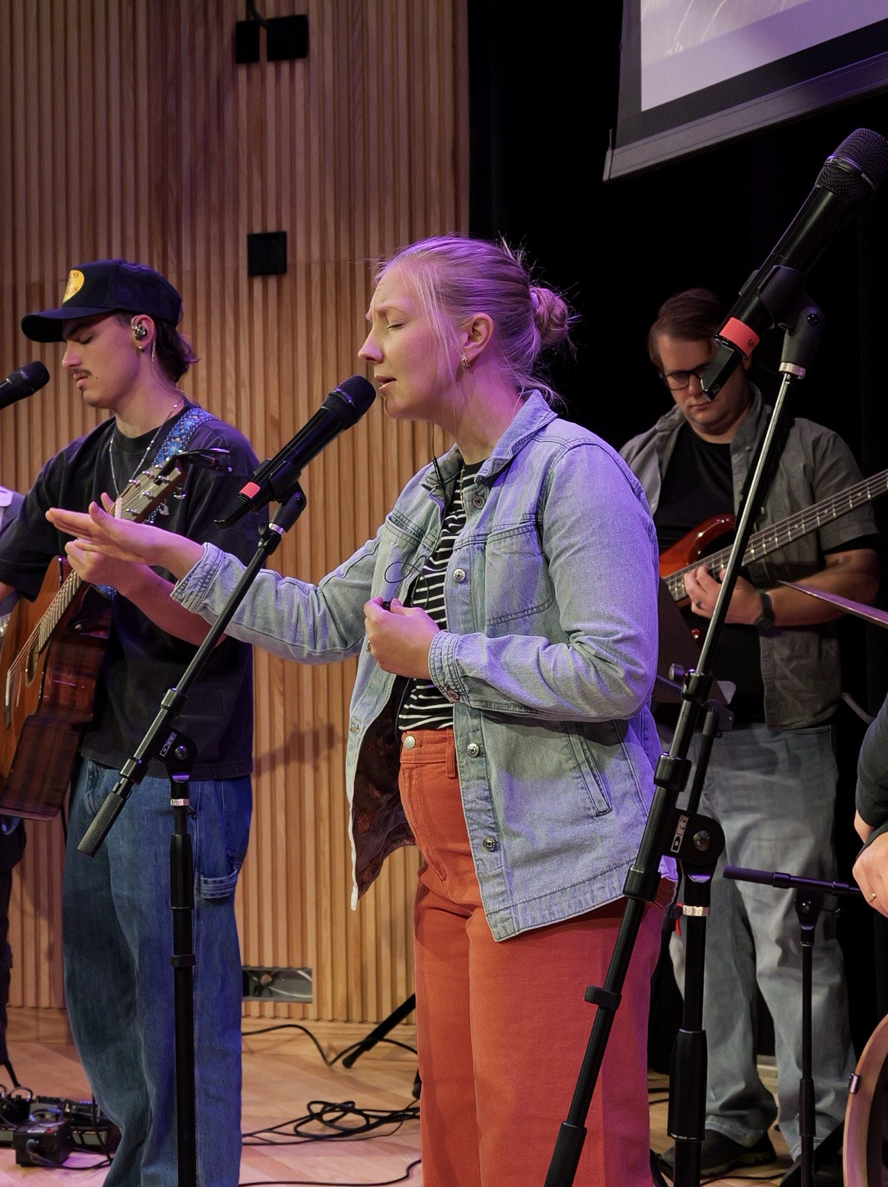 Three musicians worshipping on stage. Engaging spirit filled worship services in Woodbury.