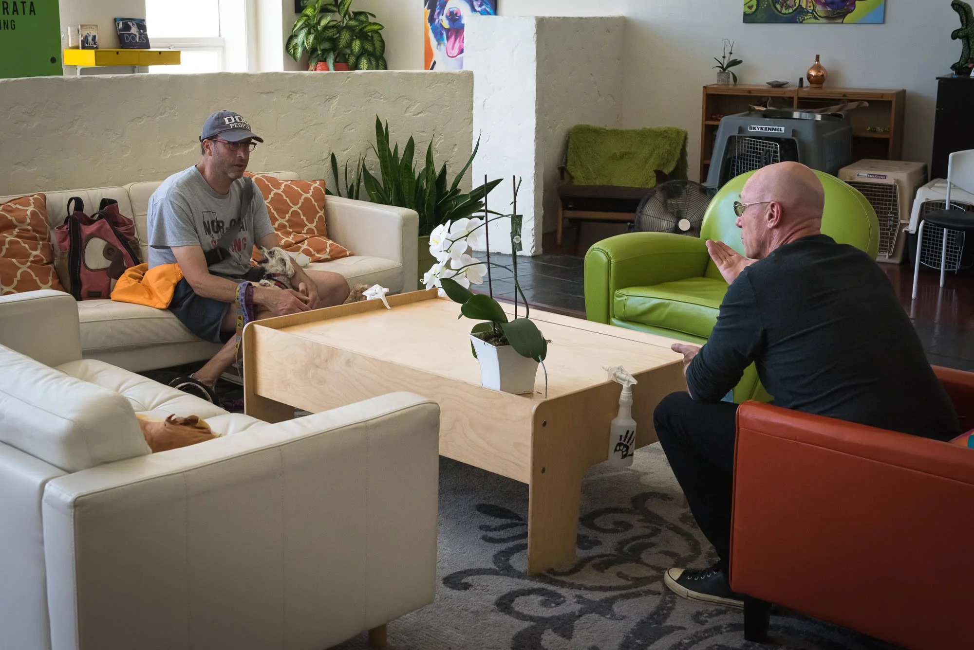 Dan Perata talking with a client and their dog in the lounge at the San Francisco facility