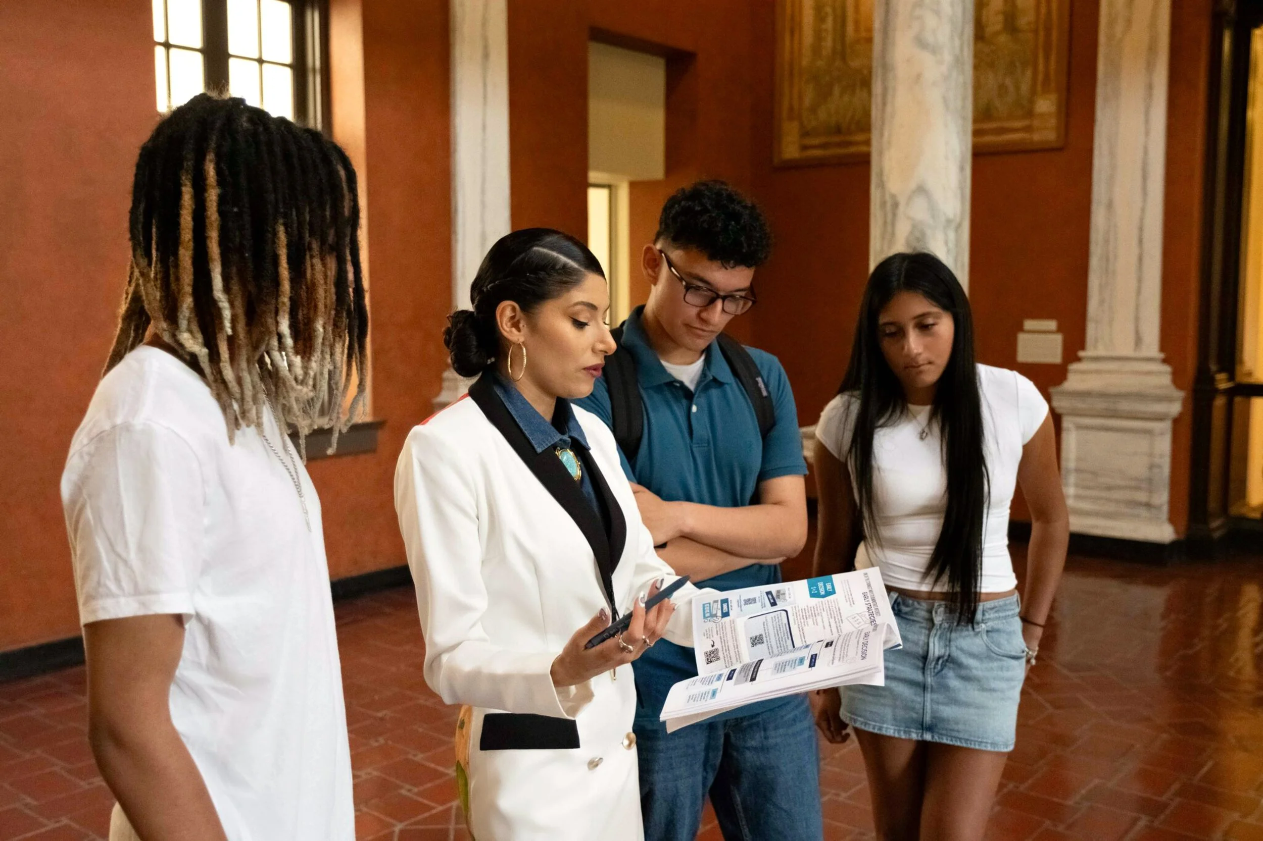 Mayra Valle reviewing college planning materials with high school students.