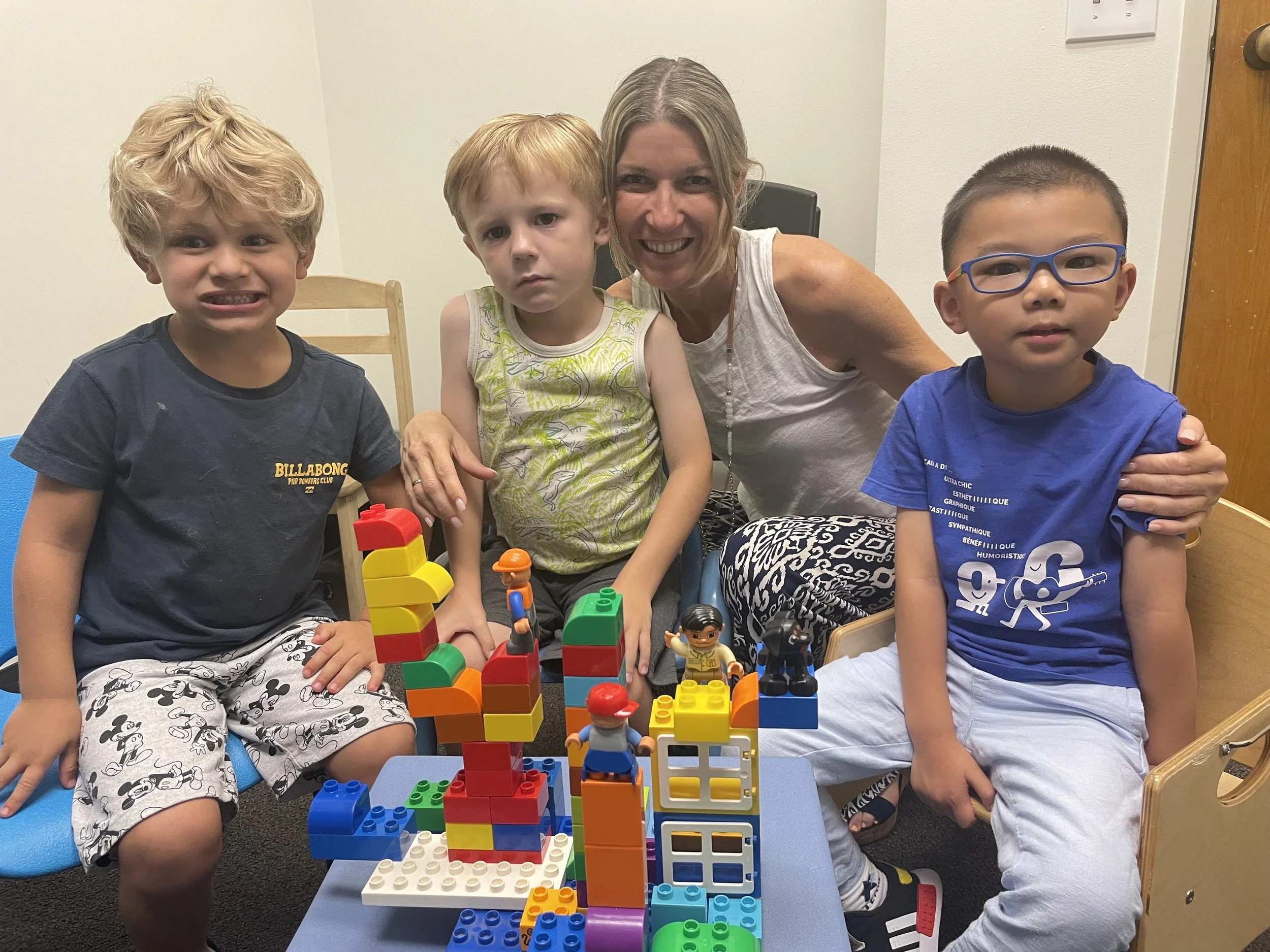 Four children playing legos and sharing during social skills