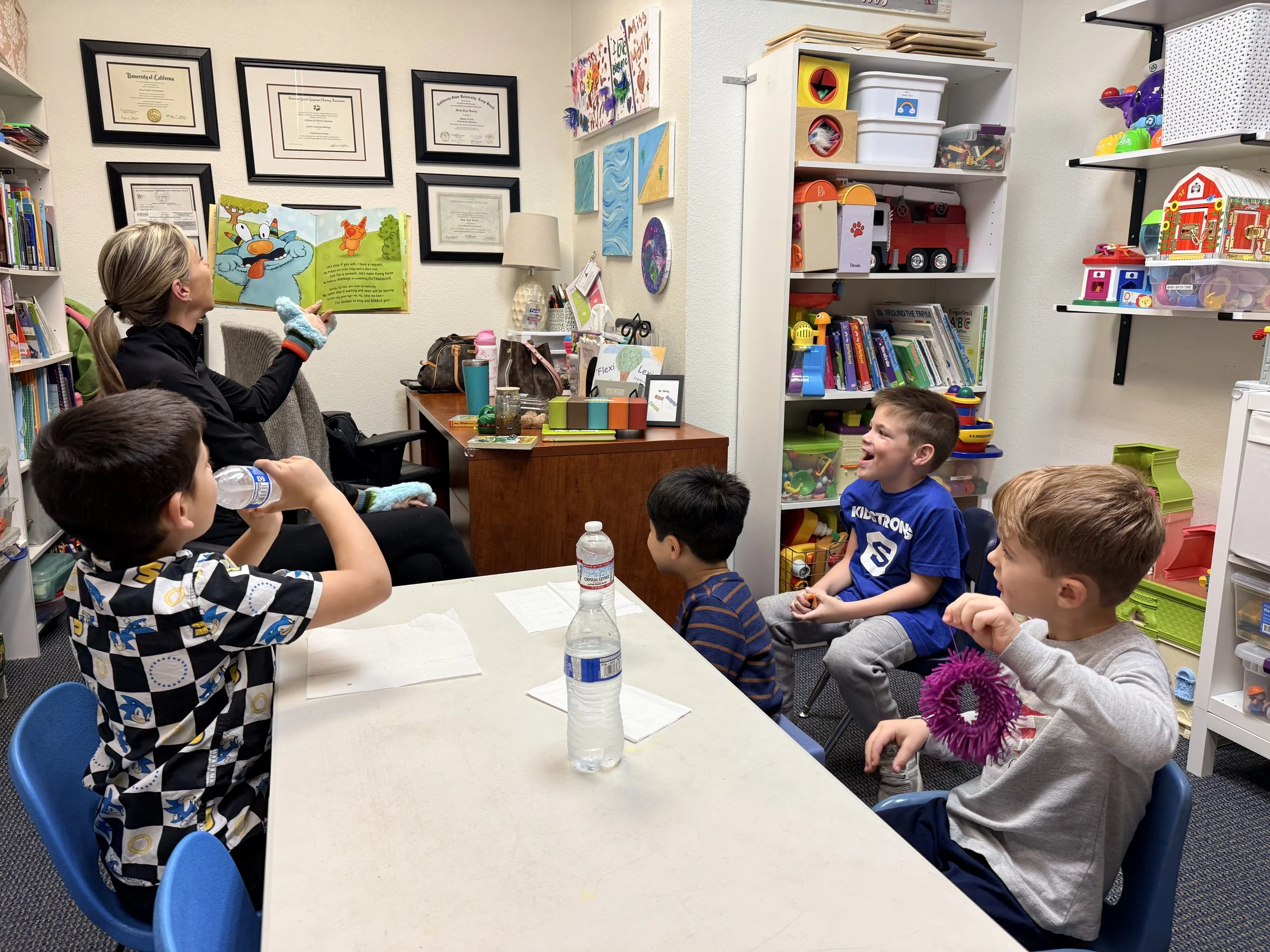 Speech and Language Pathologists reading a book about impulse control with children in social skills group