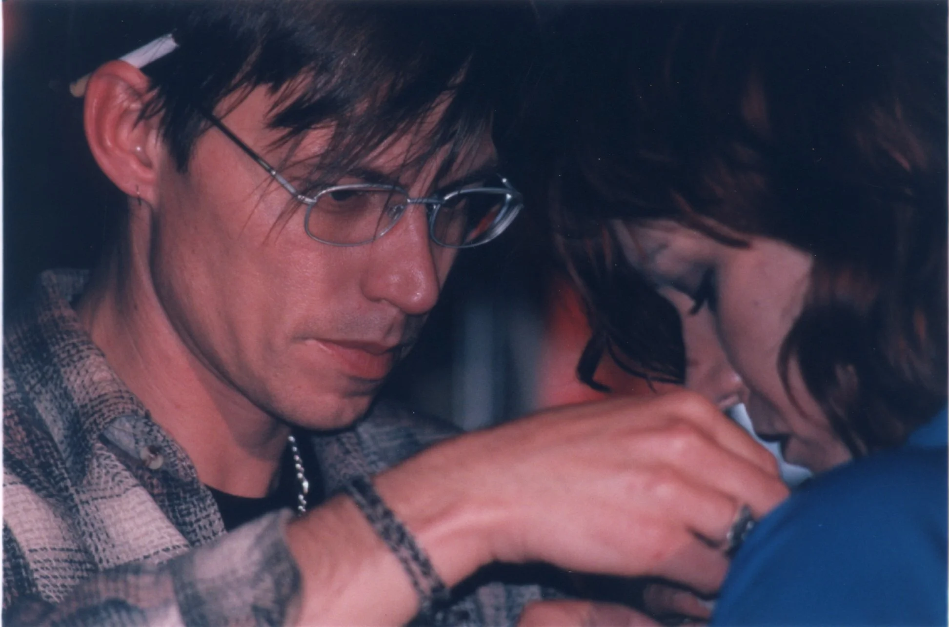 Sound engineer on punk independent movie set affixes lavalier to actress during production of late-90s NYC indie movie 'Threat'.