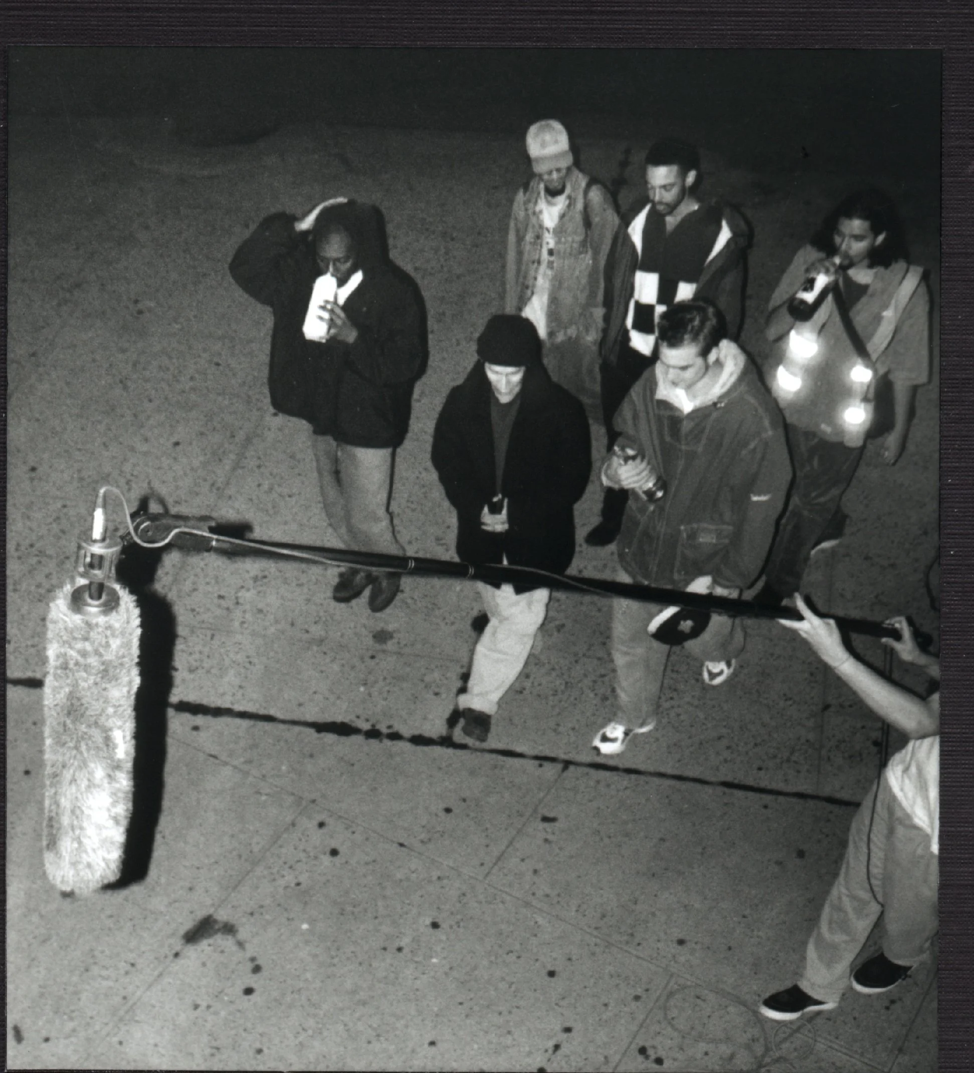 Independent film sound engineer holds boom over exterior night scene during production of late-90s NYC indie movie 'Threat'.