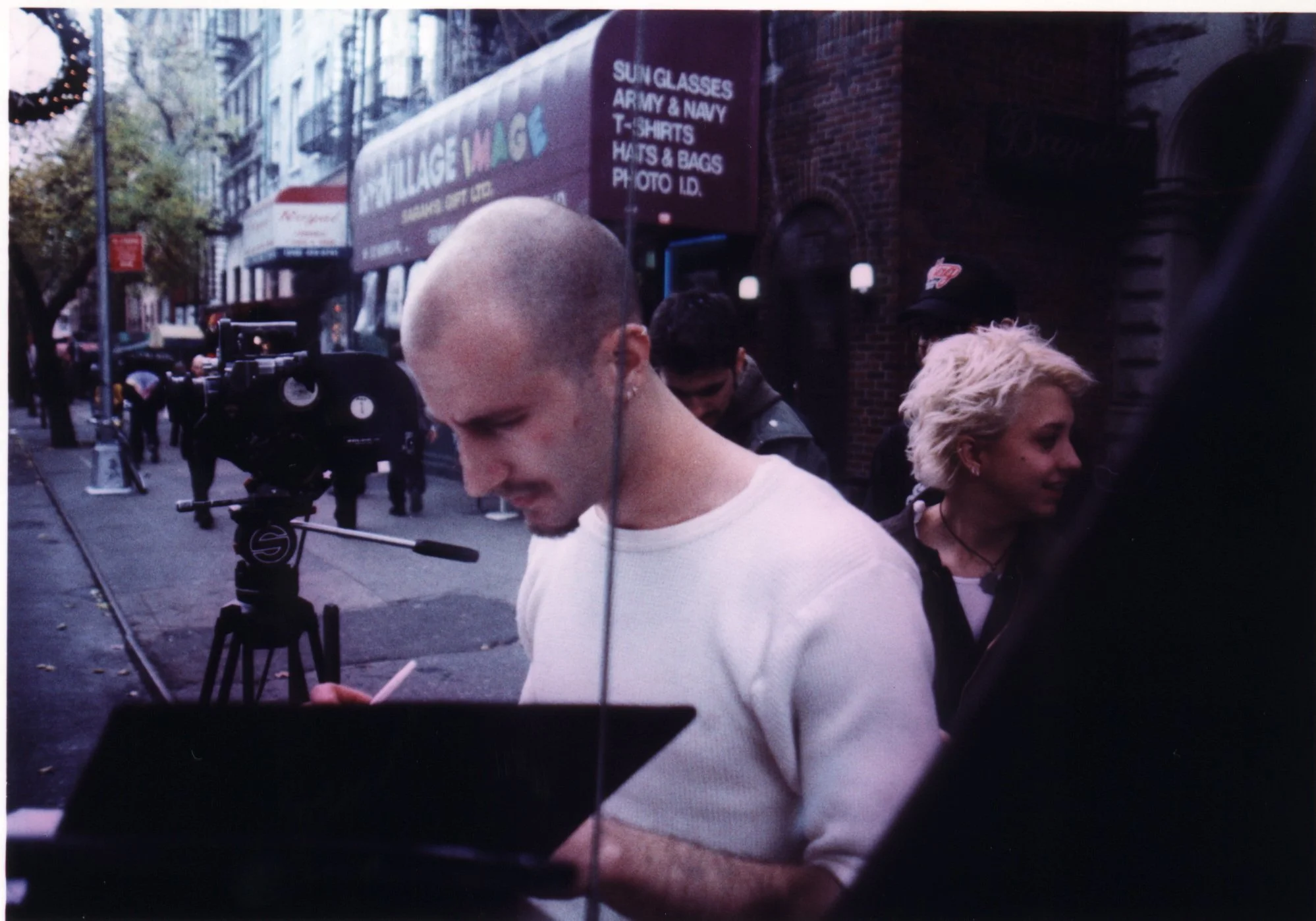 Independent film cinematographer with 16mm camera on St. Mark's Place in NYC during production of punk indie movie 'Threat'.
