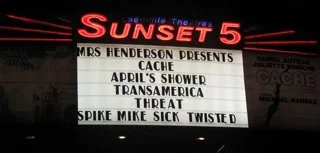 Hollywood's Laemmle Sunset 5 movie theater marquee displaying the film titles for 'Sunset 5', including 'Cache', 'April's Shower', 'Transamerica', 'Threat', and 'Spike and Mike Sick and Twisted Animation'.