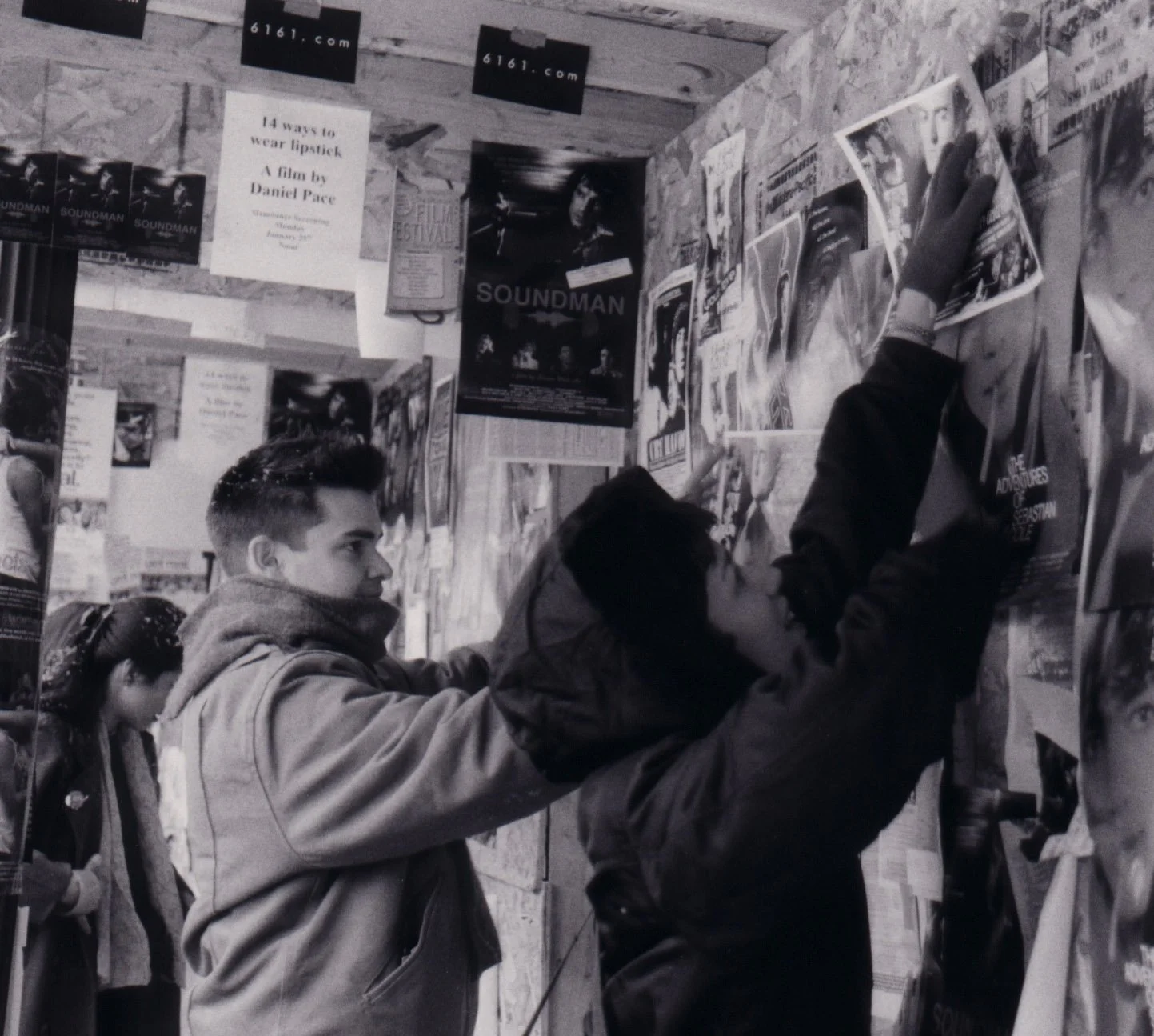 Independent filmmakers at Sundance Film Festival staple posters for indie movie 'Theat' in street promotions marketing campaign.