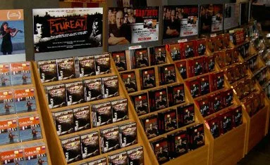 Multiple racks of DVDs and Blu-ray movies on display in Tower Records NYC including independent punk movie 'Threat' and HBO series 'The Sopranos.'