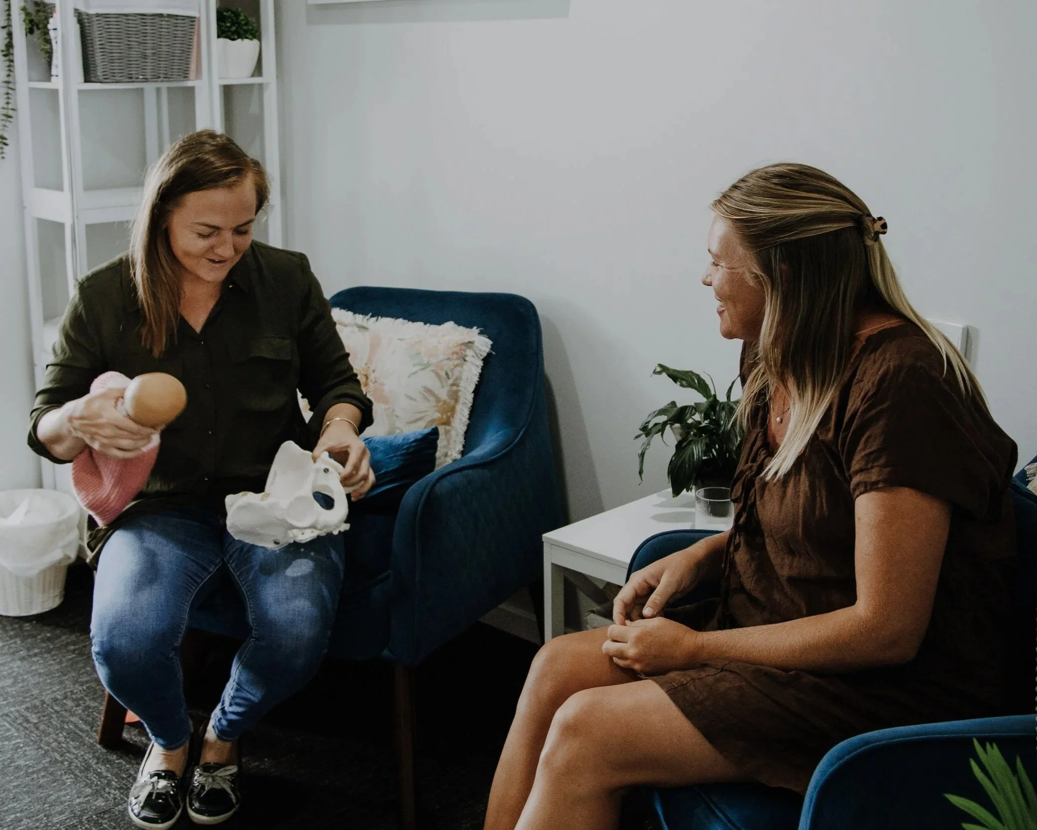 Yanna & a pregnant woman having an antenatal appointment face to face in our Bundaberg clinic, discussing birth education surrounding the pelvis.