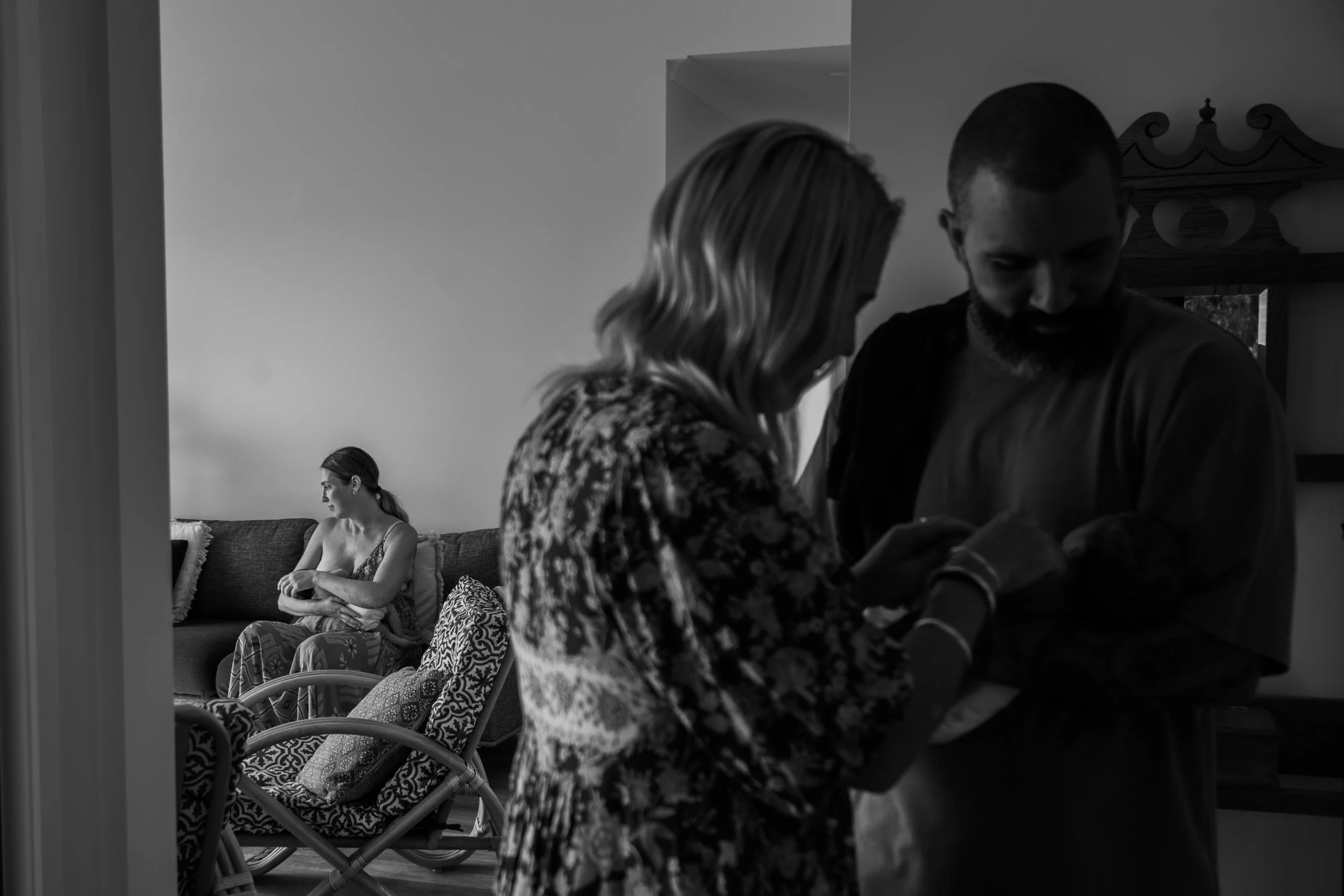 A twin mother having a routine postnatal visit at home.