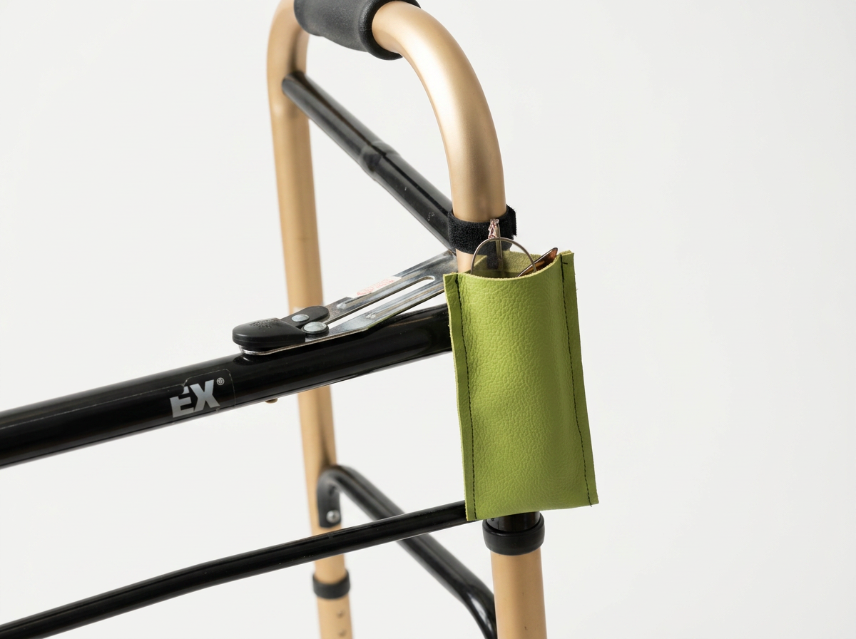 A walker with a green pouch hanging from the handlebar.