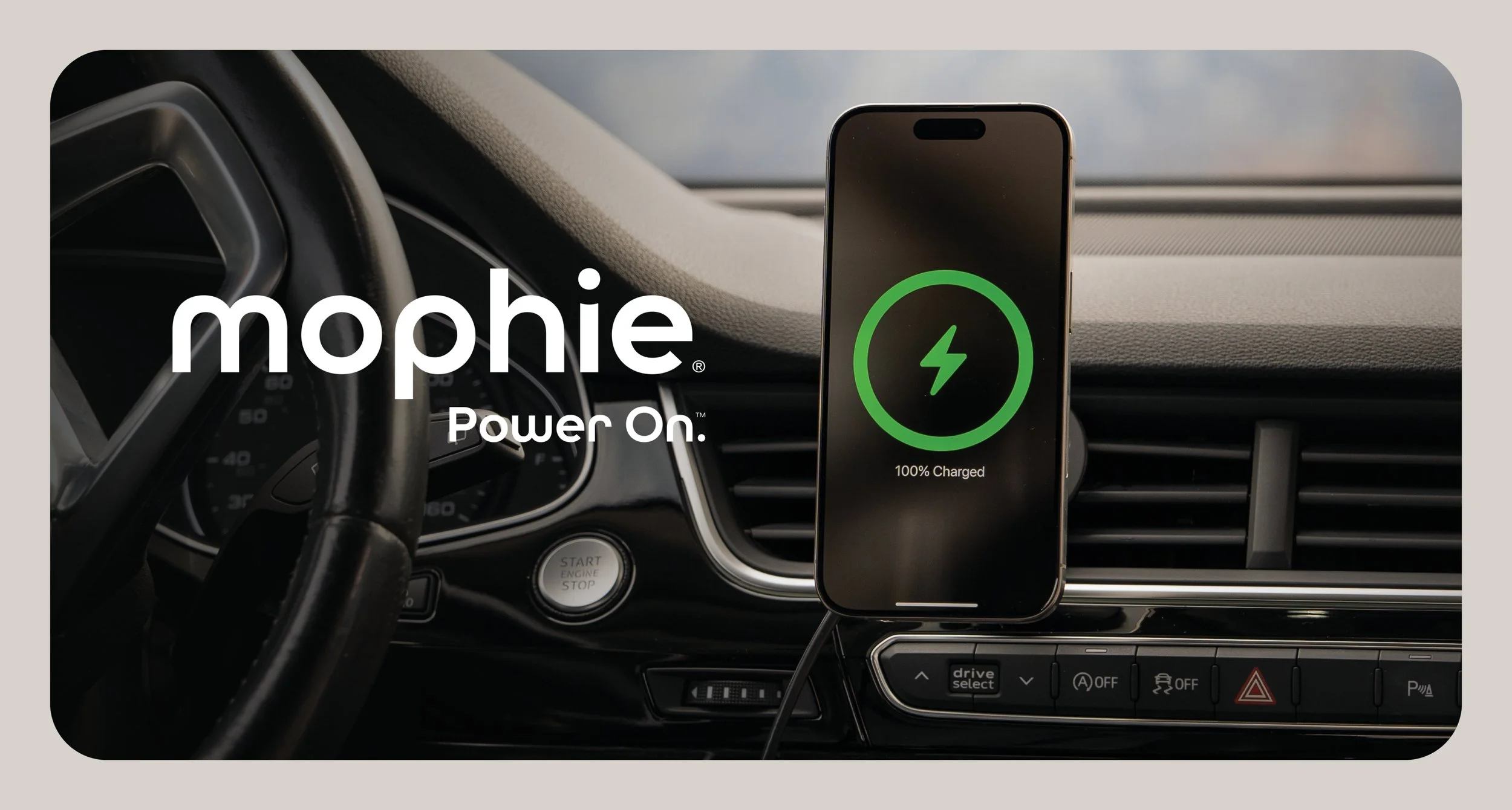 A smartphone mounted on a car dashboard shows a green charging icon and '100% Charged' text, with the words 'mophie Power On' displayed across the image.