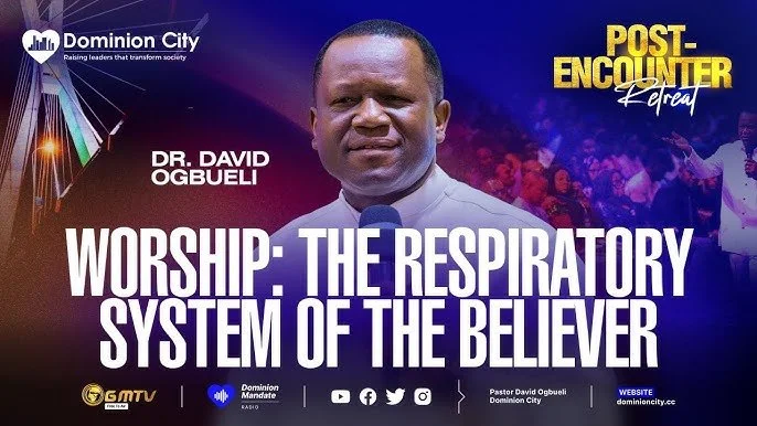 Promotional banner featuring Dr. David Ogbueli, advertising a religious event titled 'Worship- The Respiratory System of the Believer' in Dominion City, with logos, social media icons, and a colorful background.