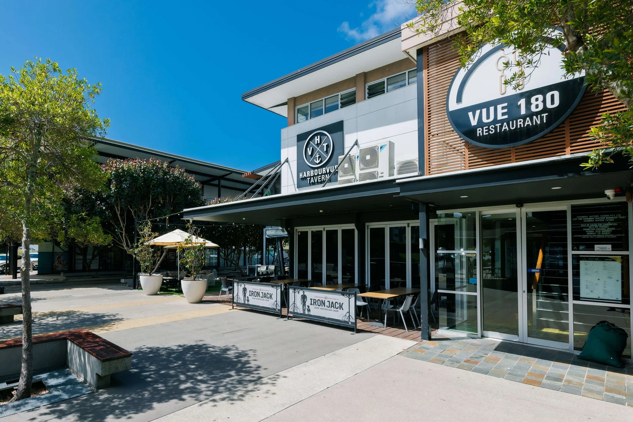 Exterior view of a restaurant with outdoor seating under a clear blue sky.