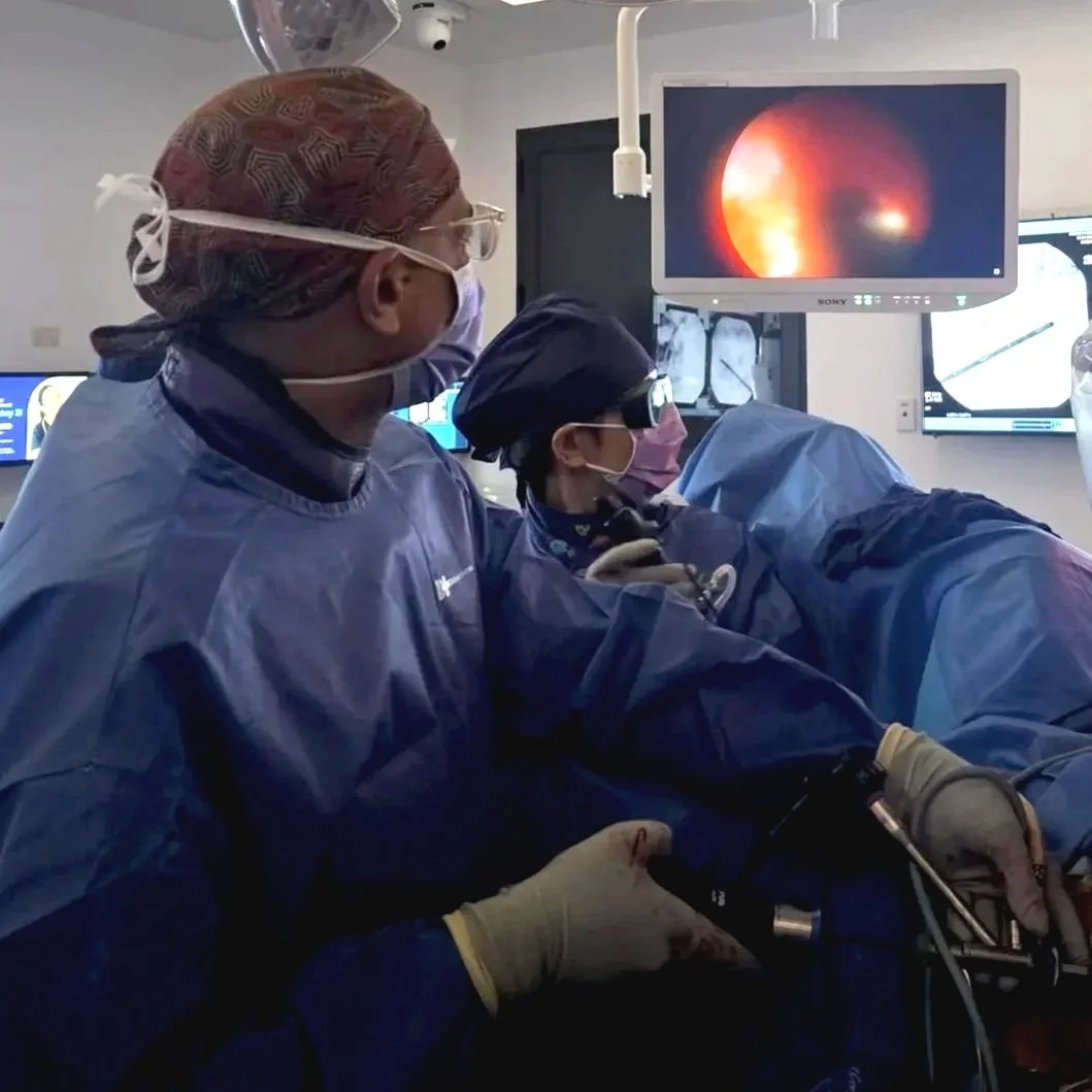 Berwick Urologist Simeon Ngweso in full scrubs conducting a procedure in a medical theatre
