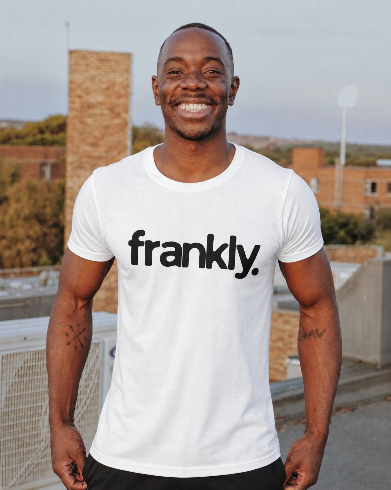 Generated with Kive.ai - Brown crewneck t-shirt FRANKLY LARGE LOGO WHITE TEE Create A studio realisistic photo shot of the Frankly Tshirt on the Model (1).png