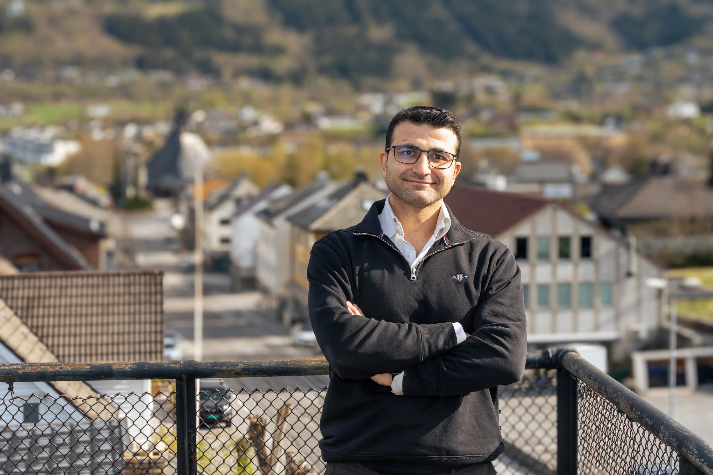 Ilyas Degirmenci, dagleg leiar i Degirmenci Eiendom, fotografert i Sykkylven sentrum med lokale eigedommar og fjellandskapet i bakgrunnen.