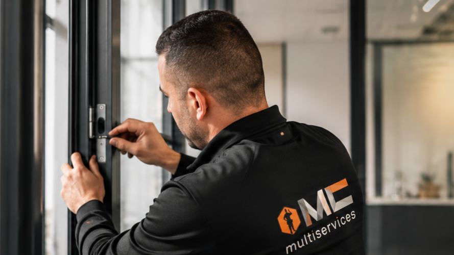 Homme en uniforme de service de nettoyage changeant une serrure.