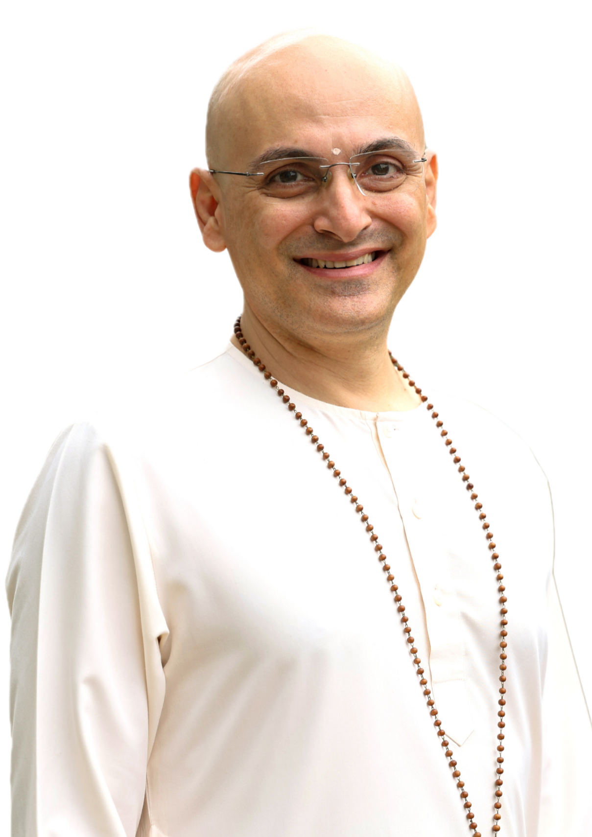 Riyaz Bharucha, smiling, wearing glasses, a white traditional Indian outfit, and a beaded necklace.