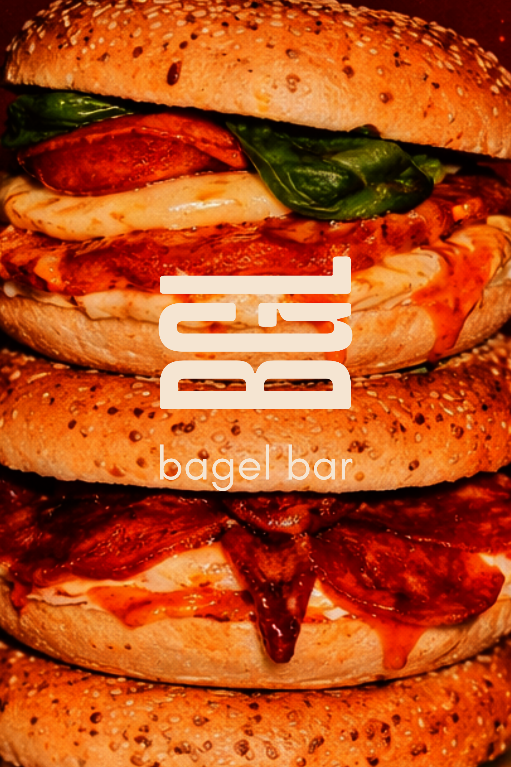 Close-up of multi-layered bagels with sesame seed bun, bacon, melted cheese, leafy greens, and sauce. The logo for 'BGL' shown as an overlay.