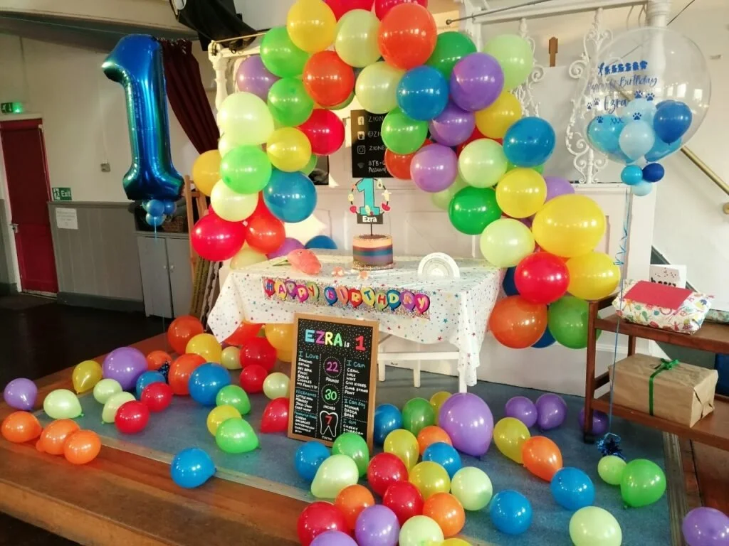 Our café hosts a colourful birthday party with balloons, cake, and birthday decorations in cute primary colours.