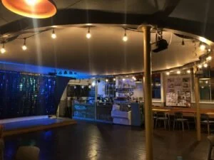 Dimly lit photo of our café with the cover over the central space but with beautiful fairy lights still around the outside.