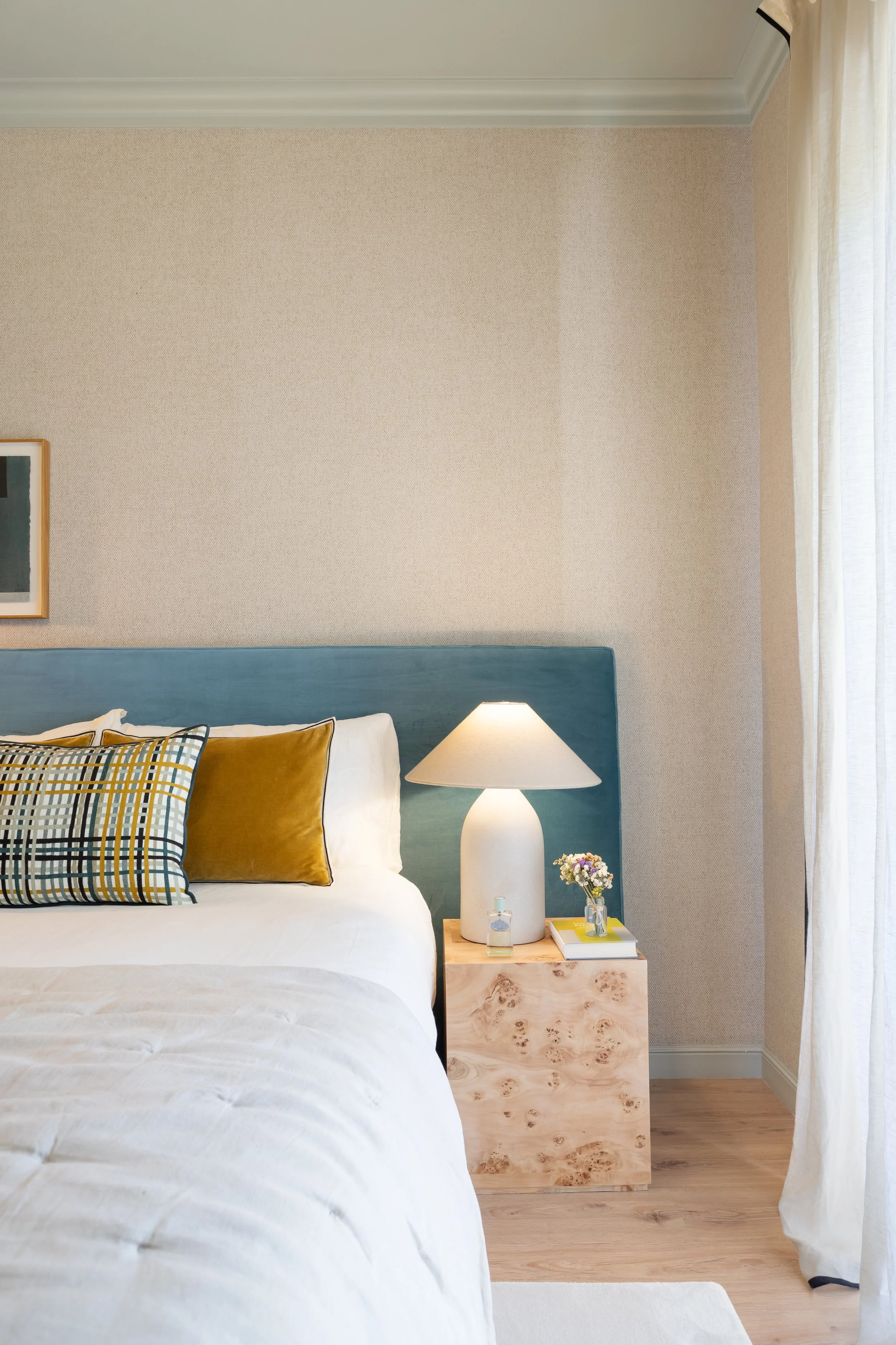 Quarto com cabeceira azul e mesa de apoio em madeira burl
