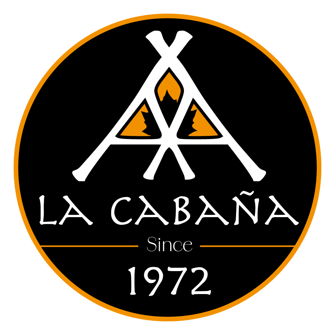 Logotipo circular negro con una frontera naranja, que tiene un diseño de varias tiendas de campaña y el texto 'LA CABAÑA' y 'Since 1972'.