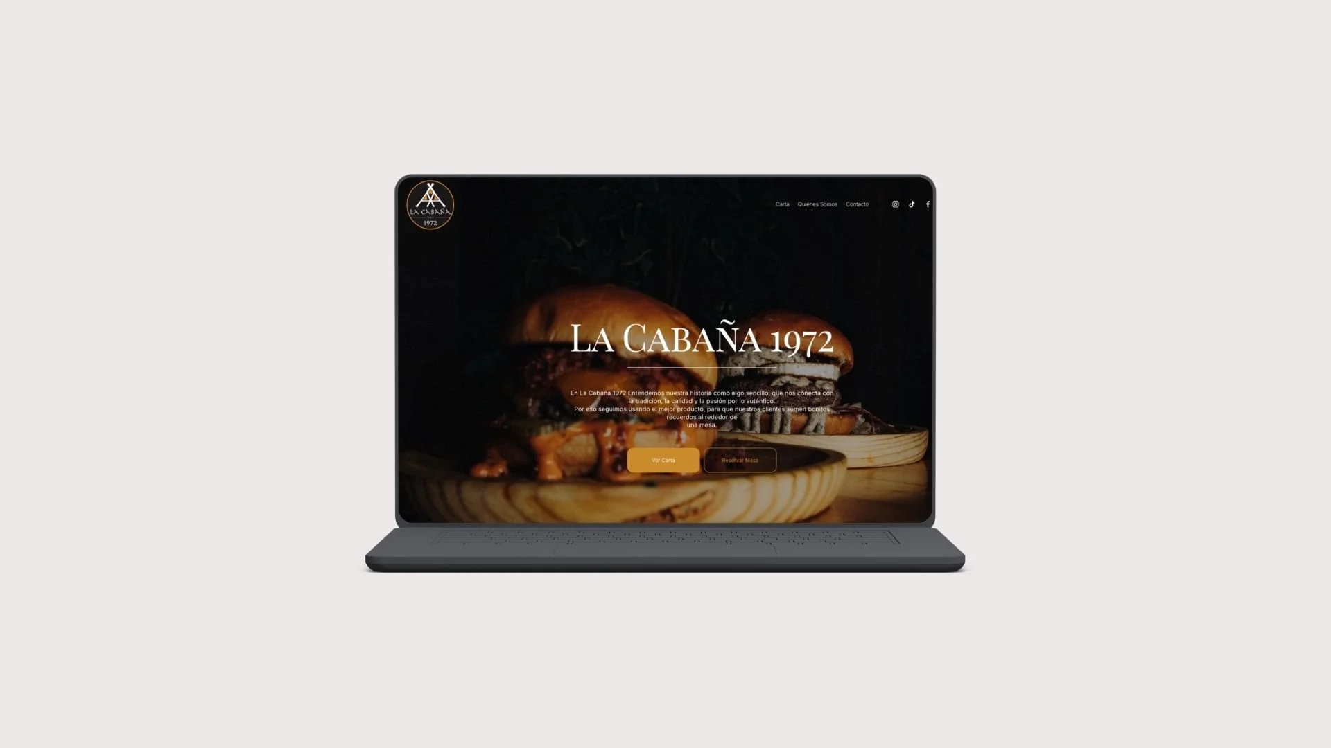 Pantalla de computadora portátil mostrando la página web de un restaurante llamado "La Cabaña 1972" con una imagen de setas en un plato de madera.