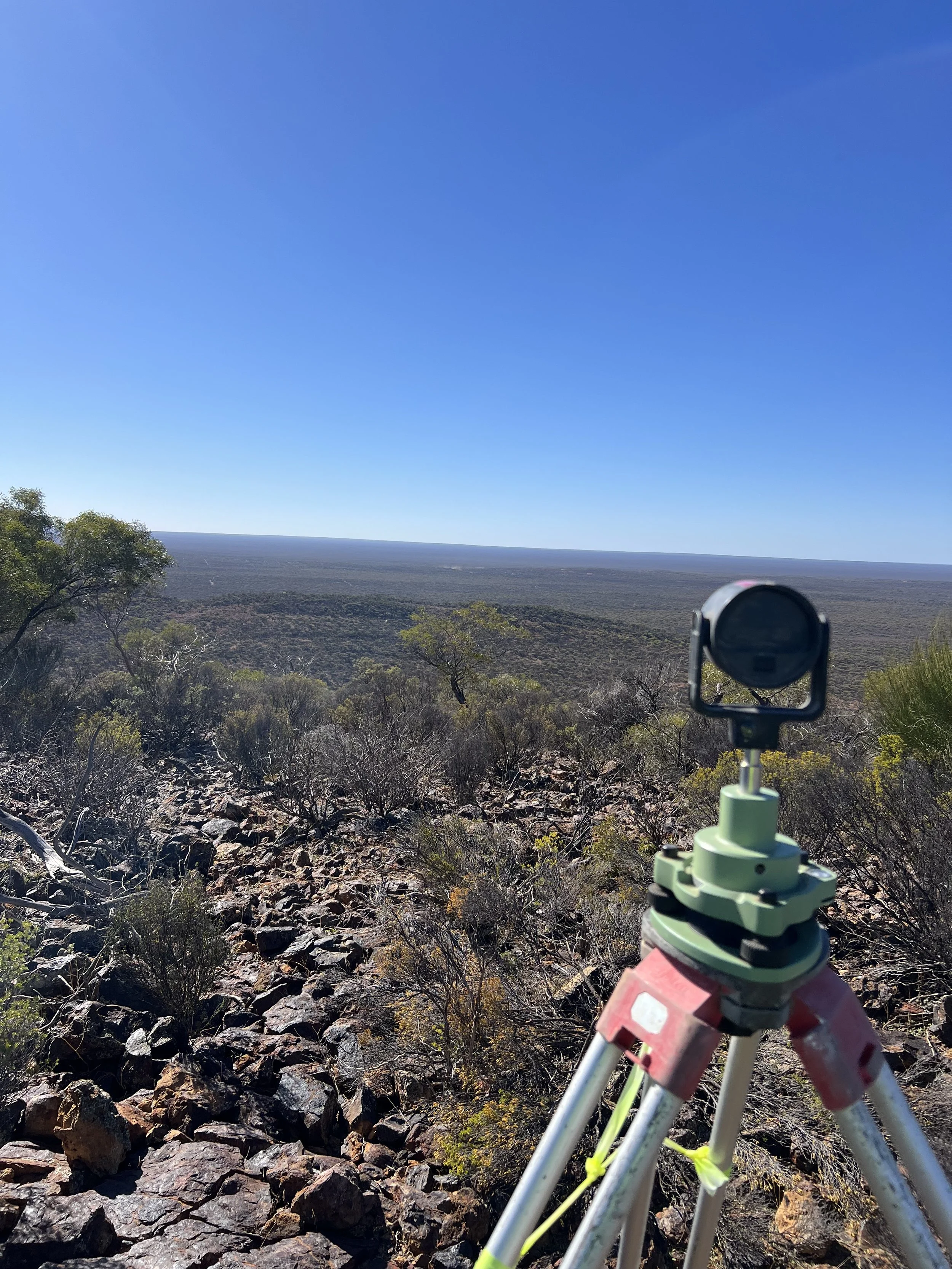Remote Survey Work overlooking dense vegetation and hills ready for a mine site control network establishment.