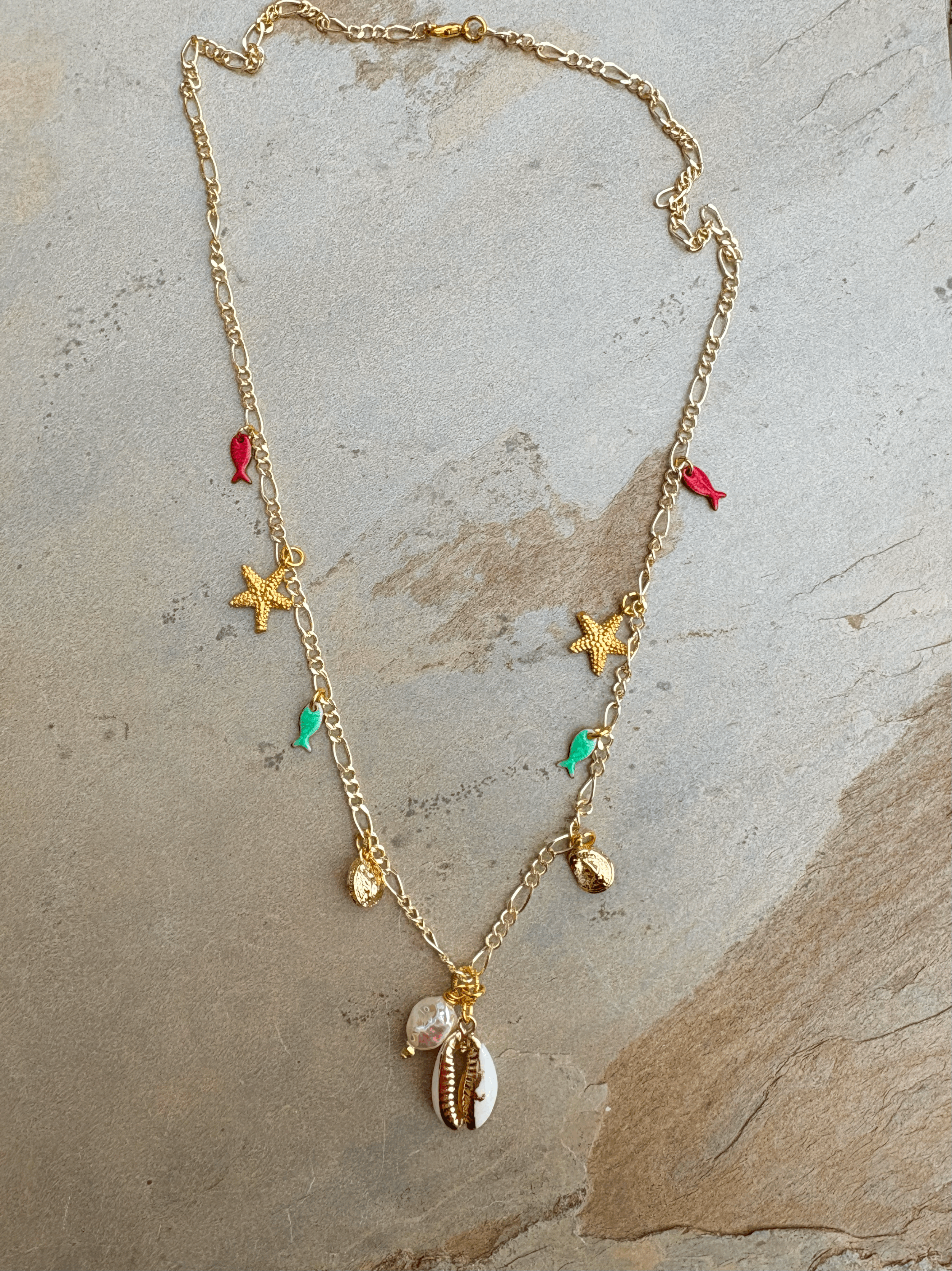 Long gold-plated charm necklace with shell pendant