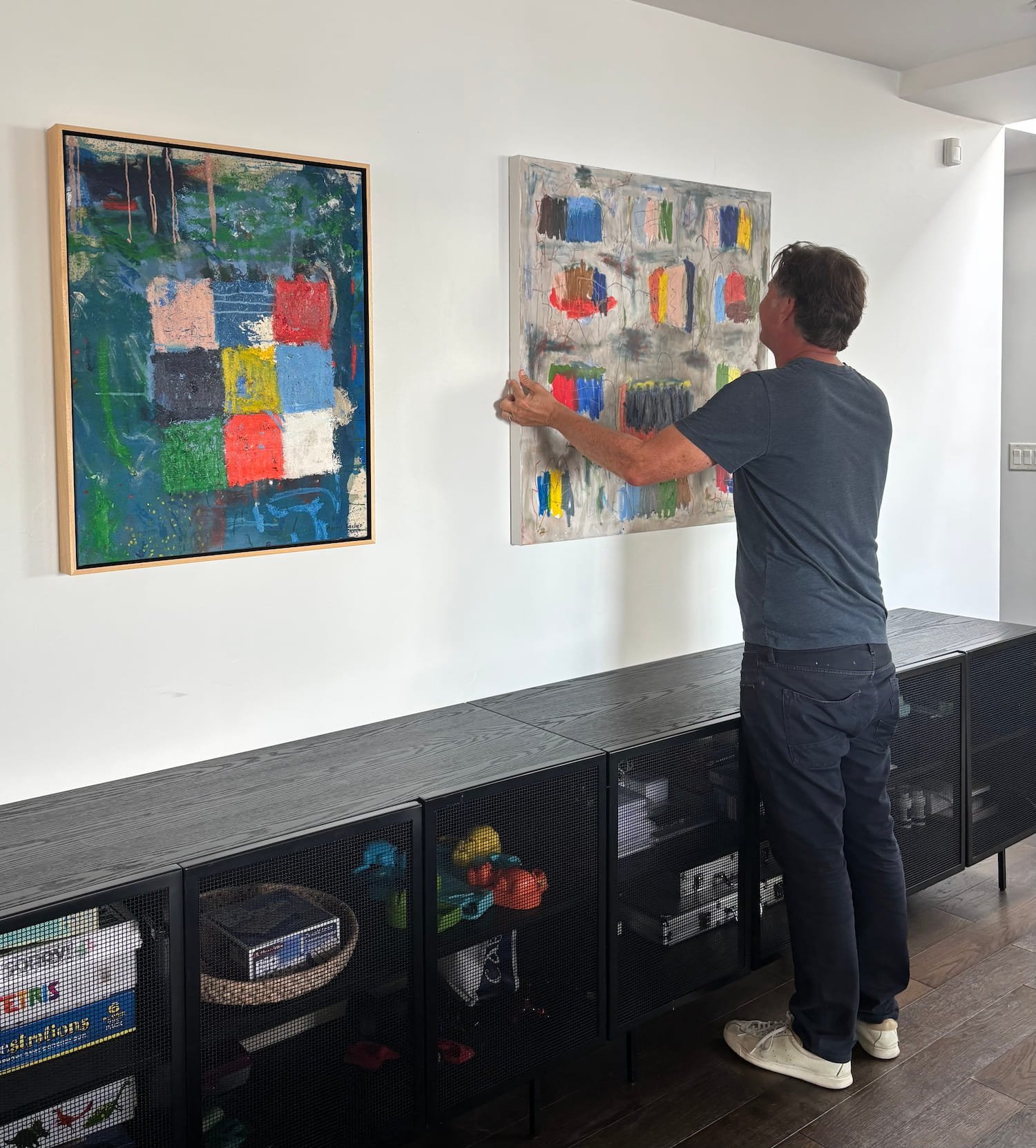 Abstract painter Marcus Bacher hanging an original painting in a collector's home