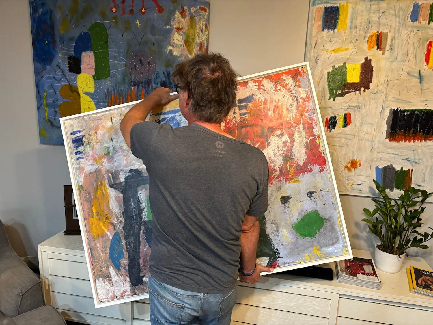 Abstract painter Marcus Bacher in his studio surrounded by original paintings in Dunedin Florida