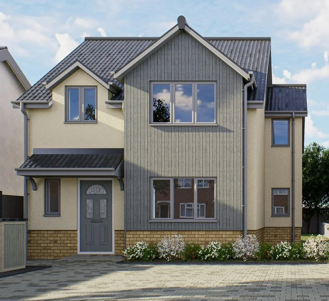 A two-story residential house with a mix of beige stucco and gray wooden siding, a dark gray tiled roof, and large windows, with a small front garden of white and green flowering bushes.