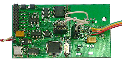 Green printed circuit board with various electronic components, wiring, and connectors.