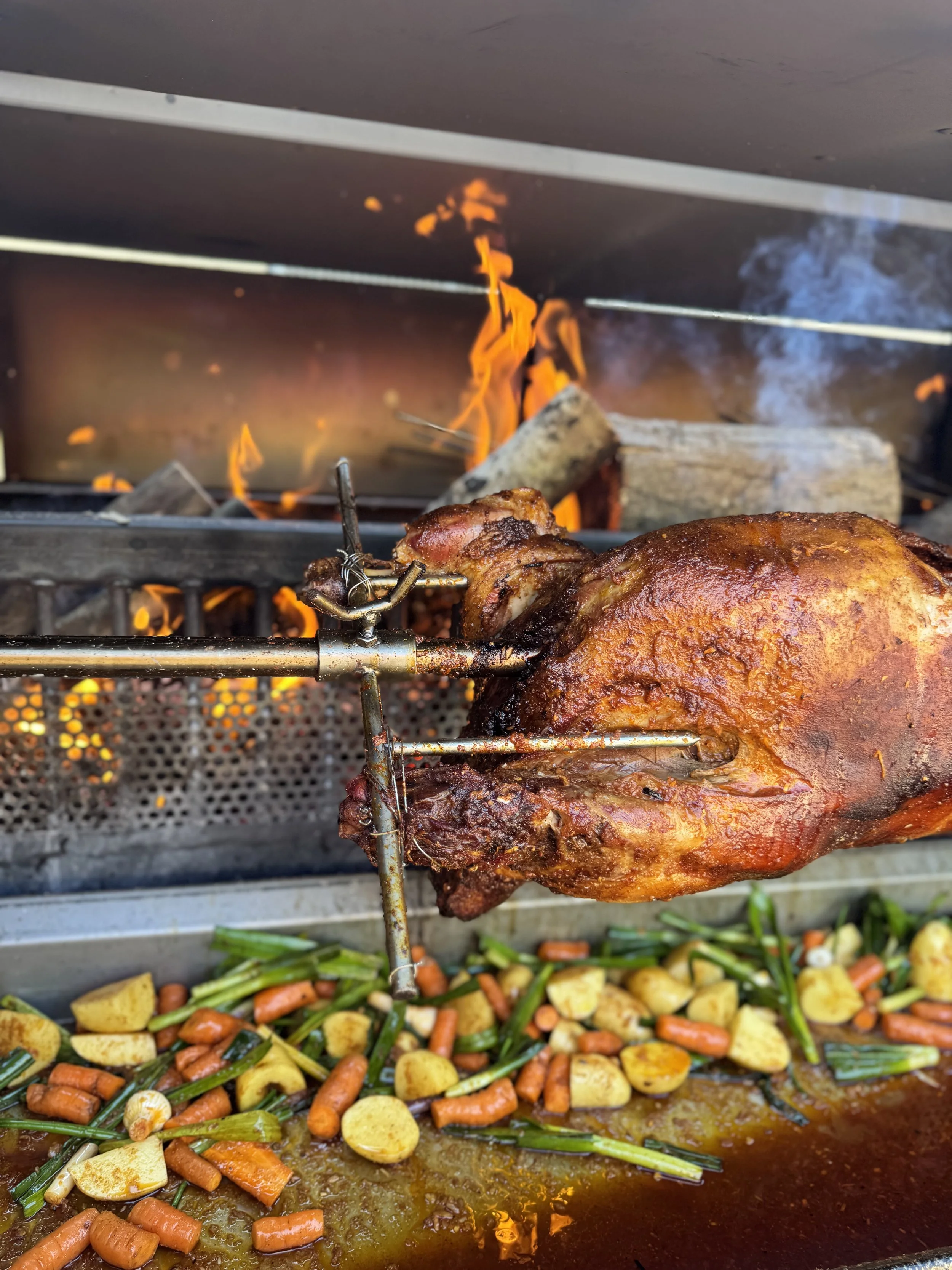 Poulet rôti à la broche avec légumes variés en dessous, cuits dans une marinade ou un jus délicieux.