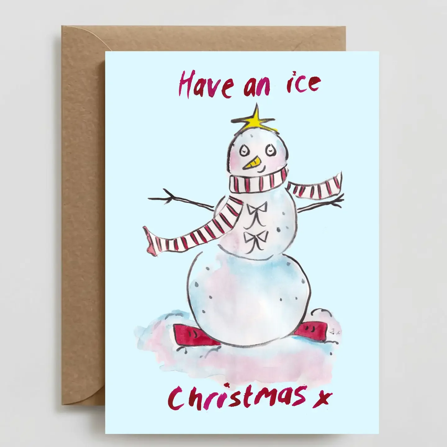 A Christmas card with a snowman illustration wearing a striped scarf, red shoes, and a yellow star on its head. The card has the text 'Have an ice Christmas' at the top and 'Christmas' at the bottom.