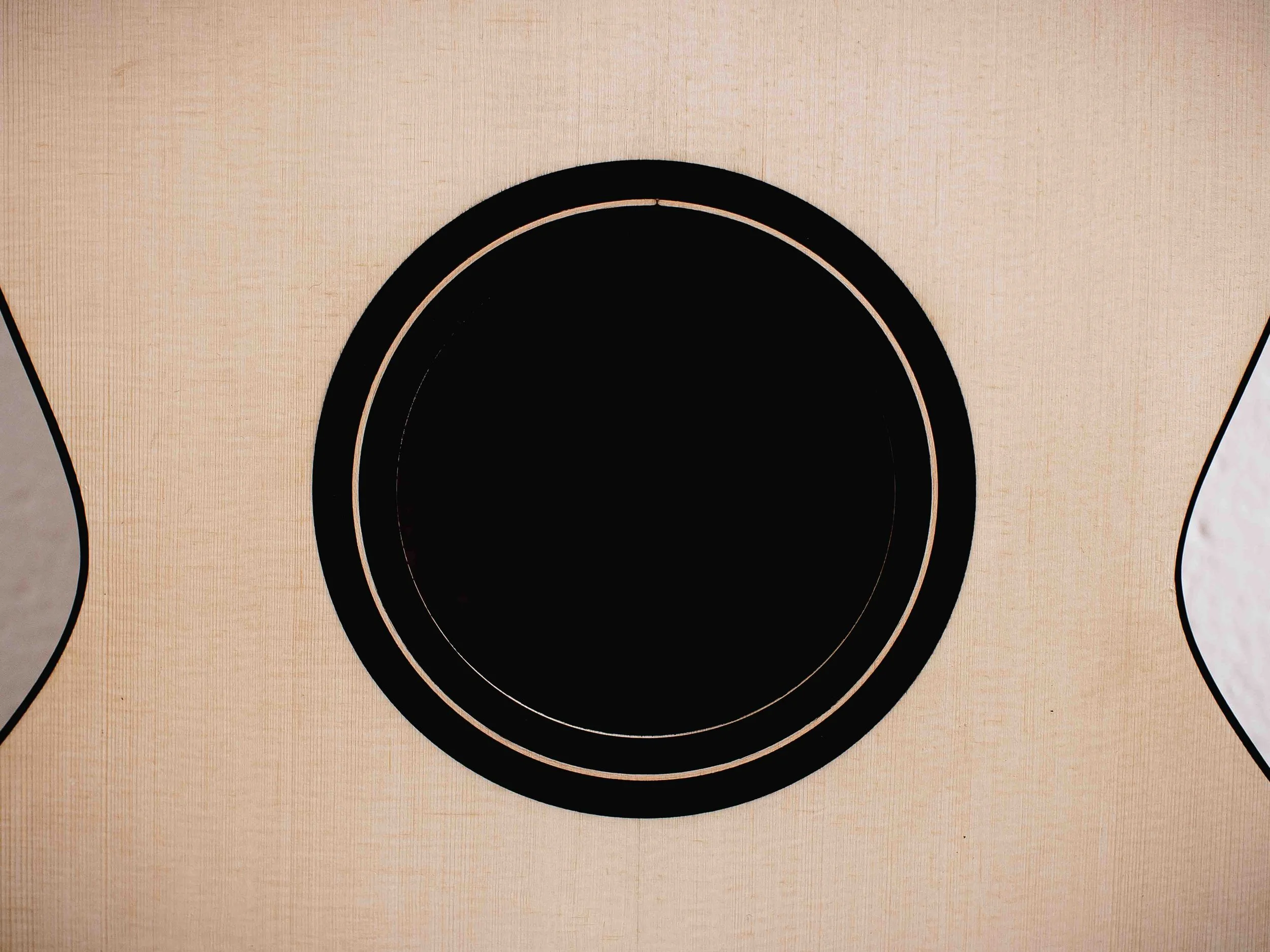 Close-up of a wooden acoustic guitar's sound hole and circular sound hole rosette.