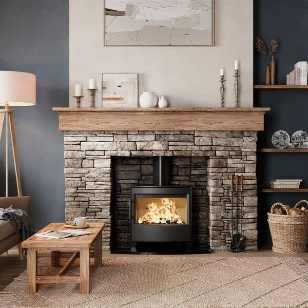 Living room with a stone fireplace, wood mantel, and a cozy fire. Decor includes candles, vases, and artwork above the mantel, with a sitting area nearby.