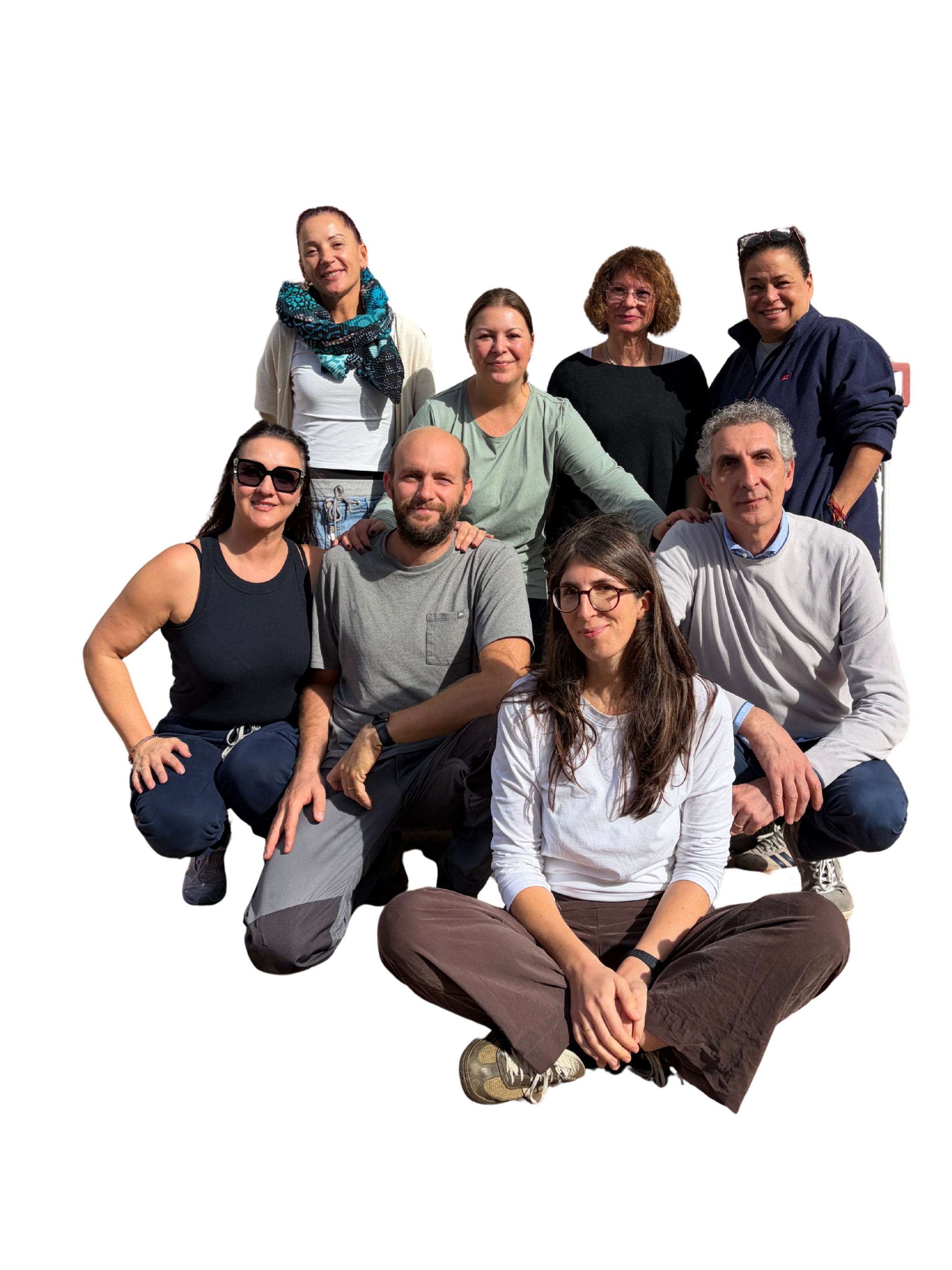 Gruppo di dieci persone sedute e in piedi, sorridenti, in un ambiente esterno, con alcune persone che indossano occhiali da sole e abbigliamento casual.