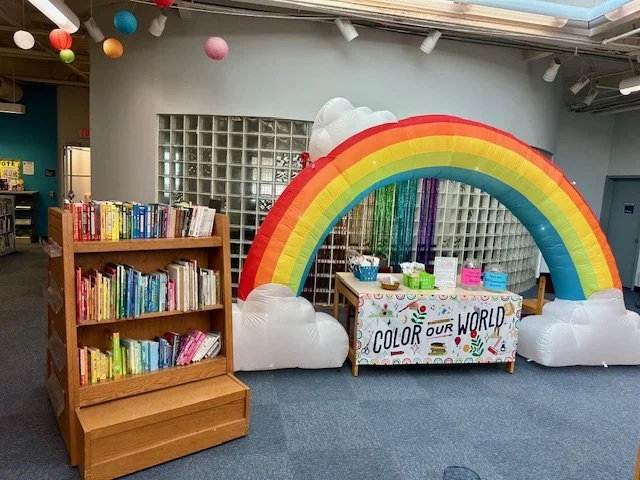Color Our World Children's Summer Reading Program inflatable rainbow and book display