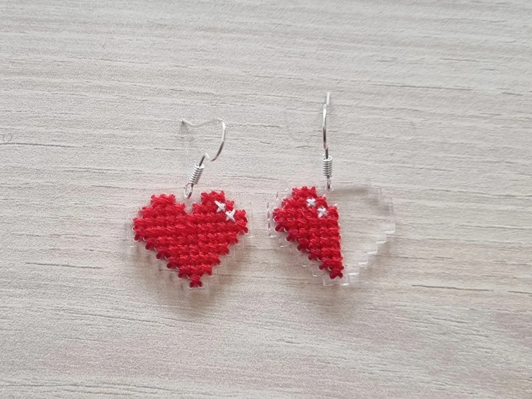 Cross stitch embroidered laser-cut acrylic earrings of my own design.