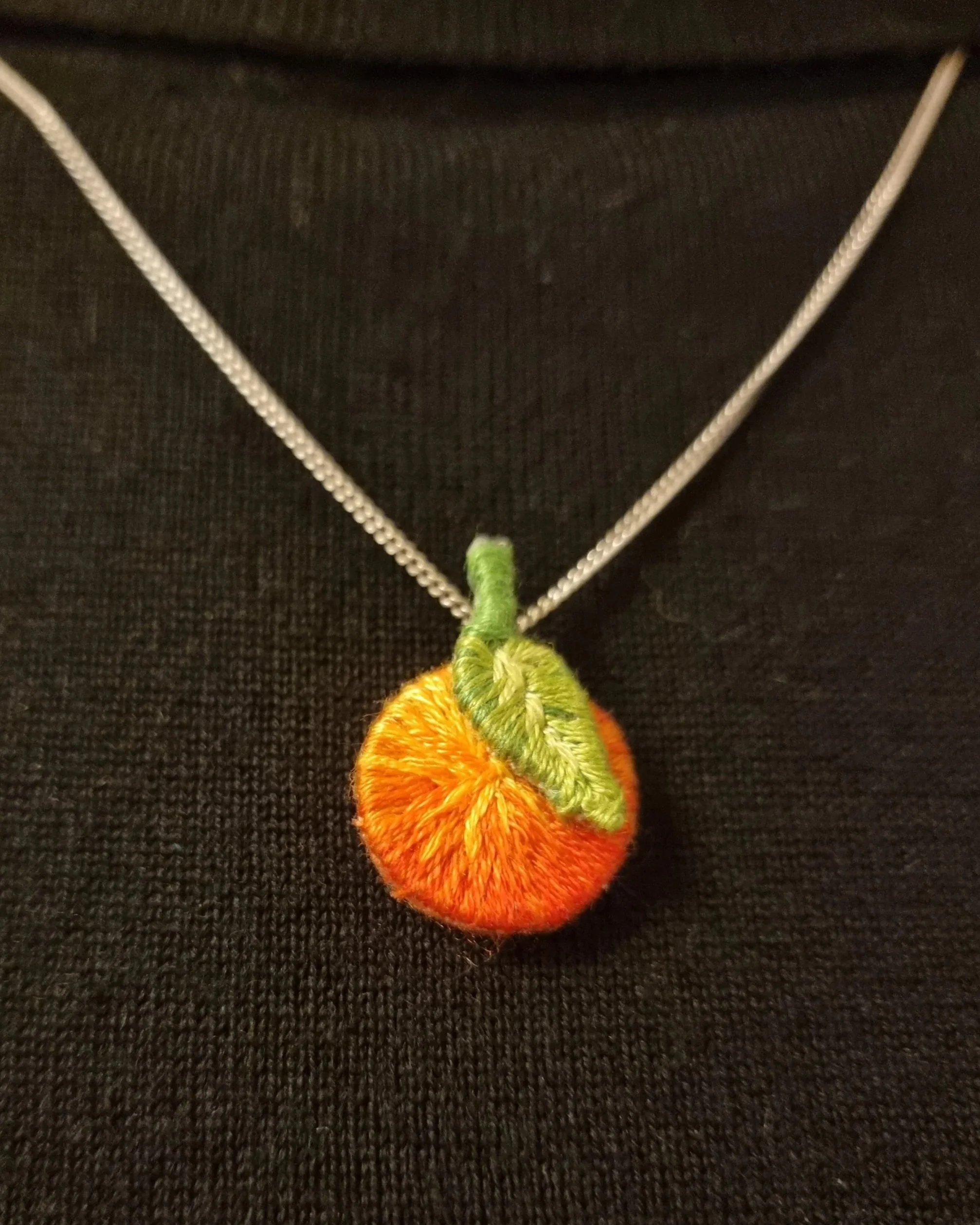 Orange embroidered pendant of my own design.