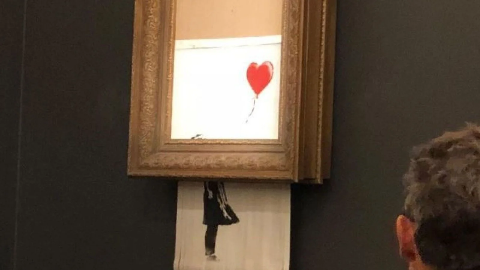 Banksy's “Girl With Balloon” shreds after its sale. Image from Sotheby's via news.sky.com.