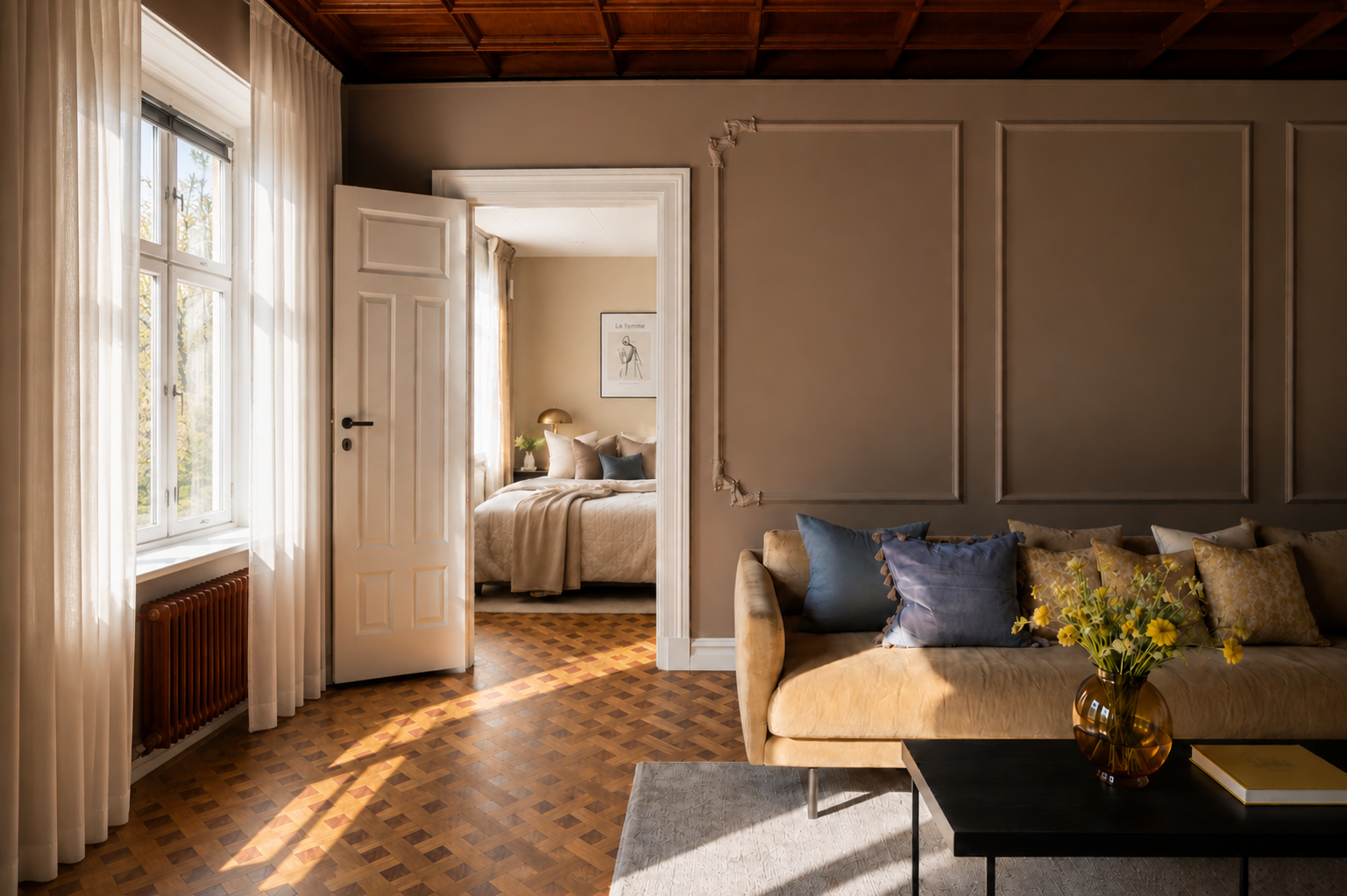 Vardagsrum med soffa, blommor, fönster och vy in till ett sovrum med säng, prydnadskuddar och väggdekoration.