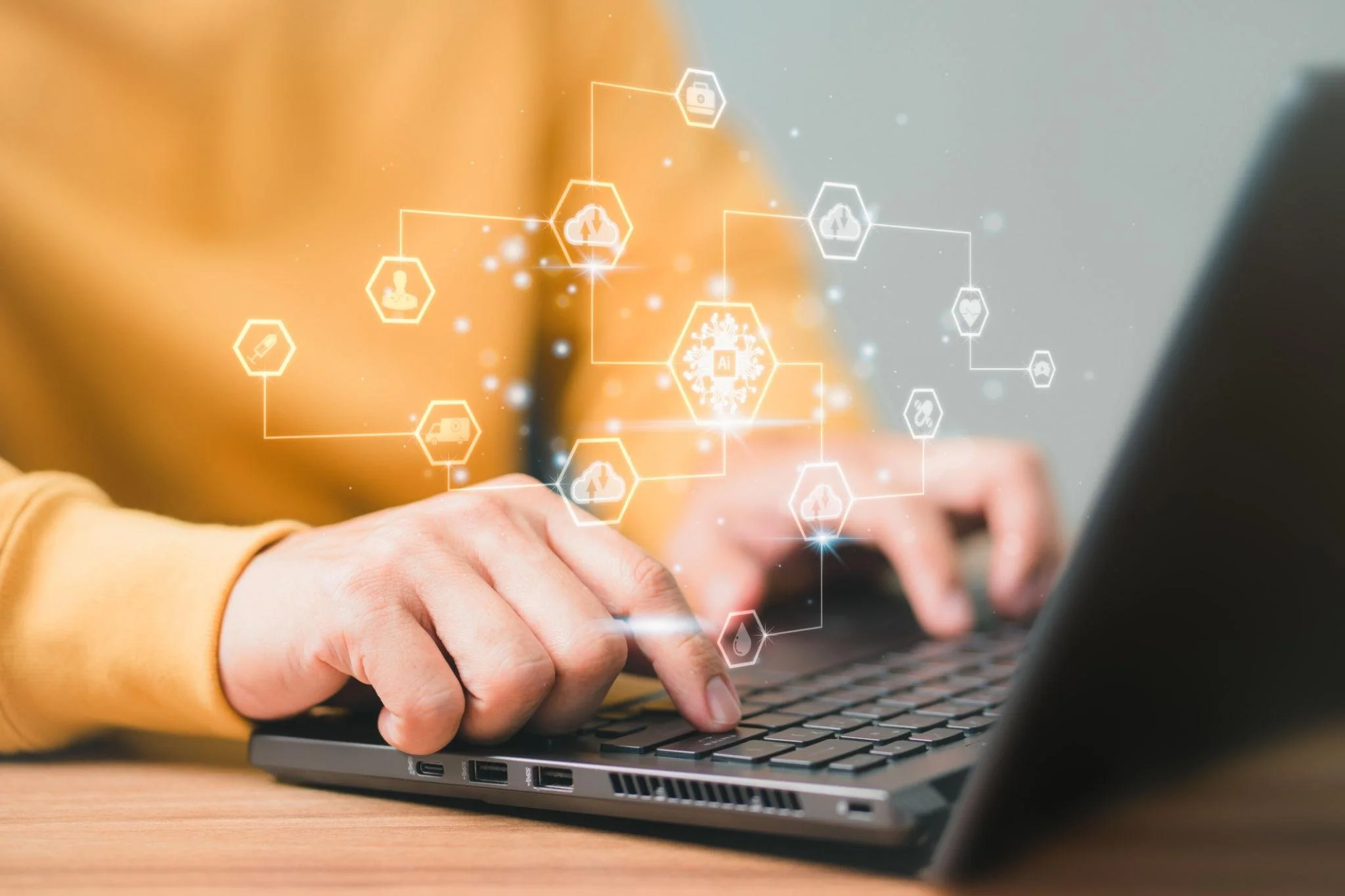 Person using a laptop with digital icons representing cloud technology, AI, and data transfer floating above the keyboard.