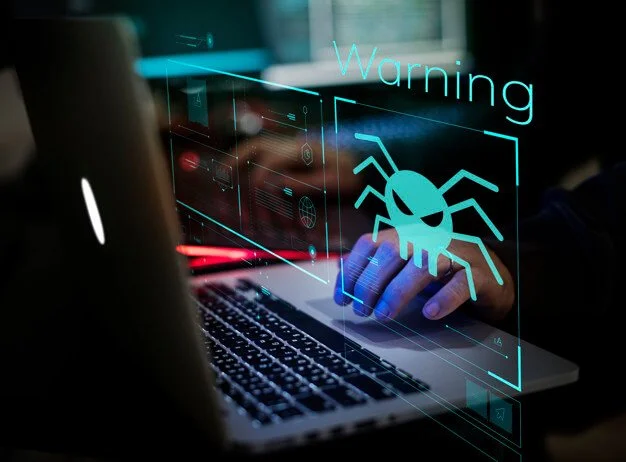 A person using a laptop with a digital warning sign of a bug or virus on the screen, indicating cybersecurity threats.